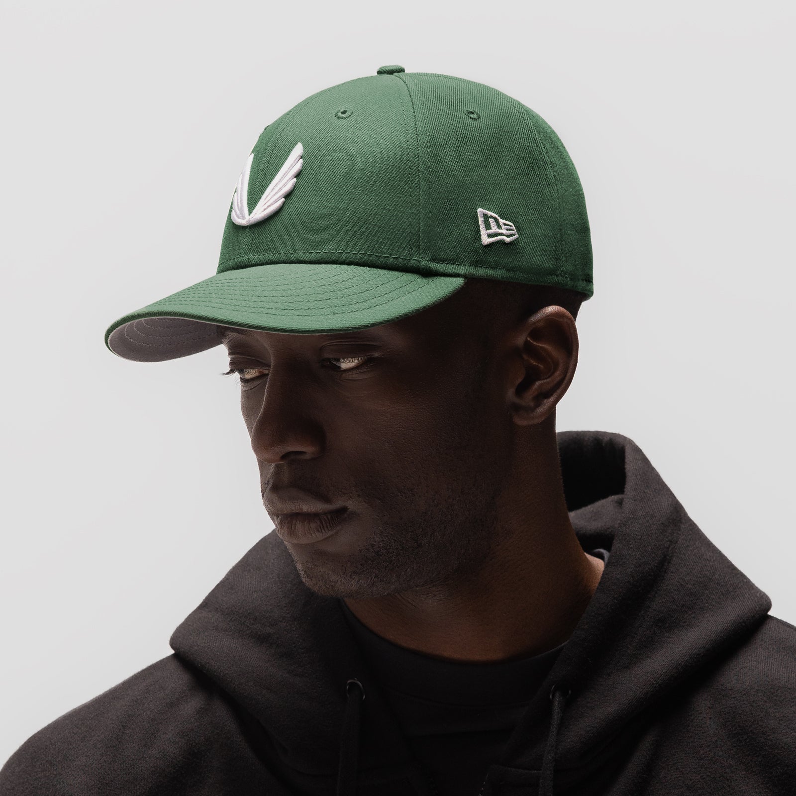 New Era 59Fifty Low Profile Hat in forest green with white wings logo, worn by model