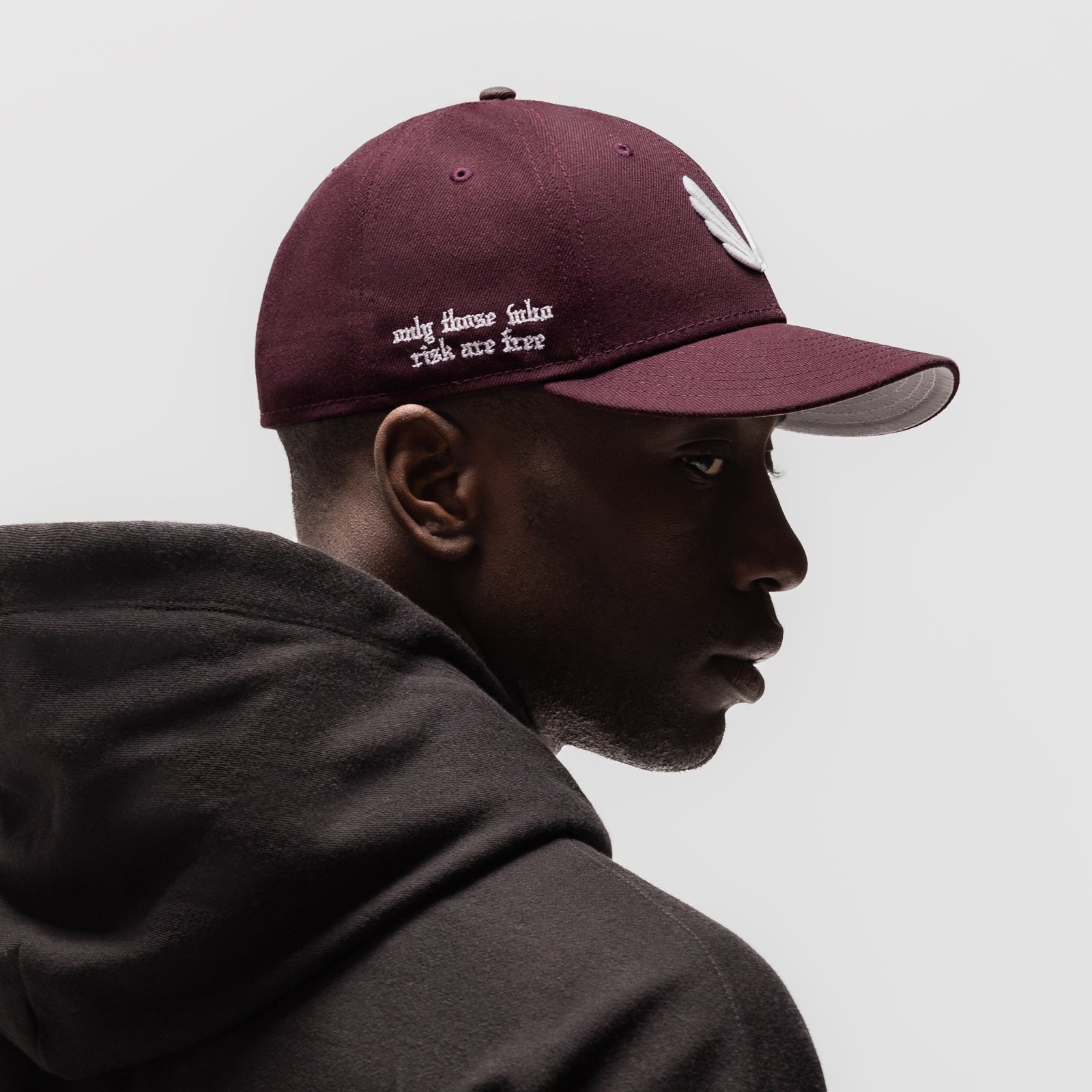 New Era 59Fifty Low Profile Hat in maroon with white wings logo, worn by model in profile view