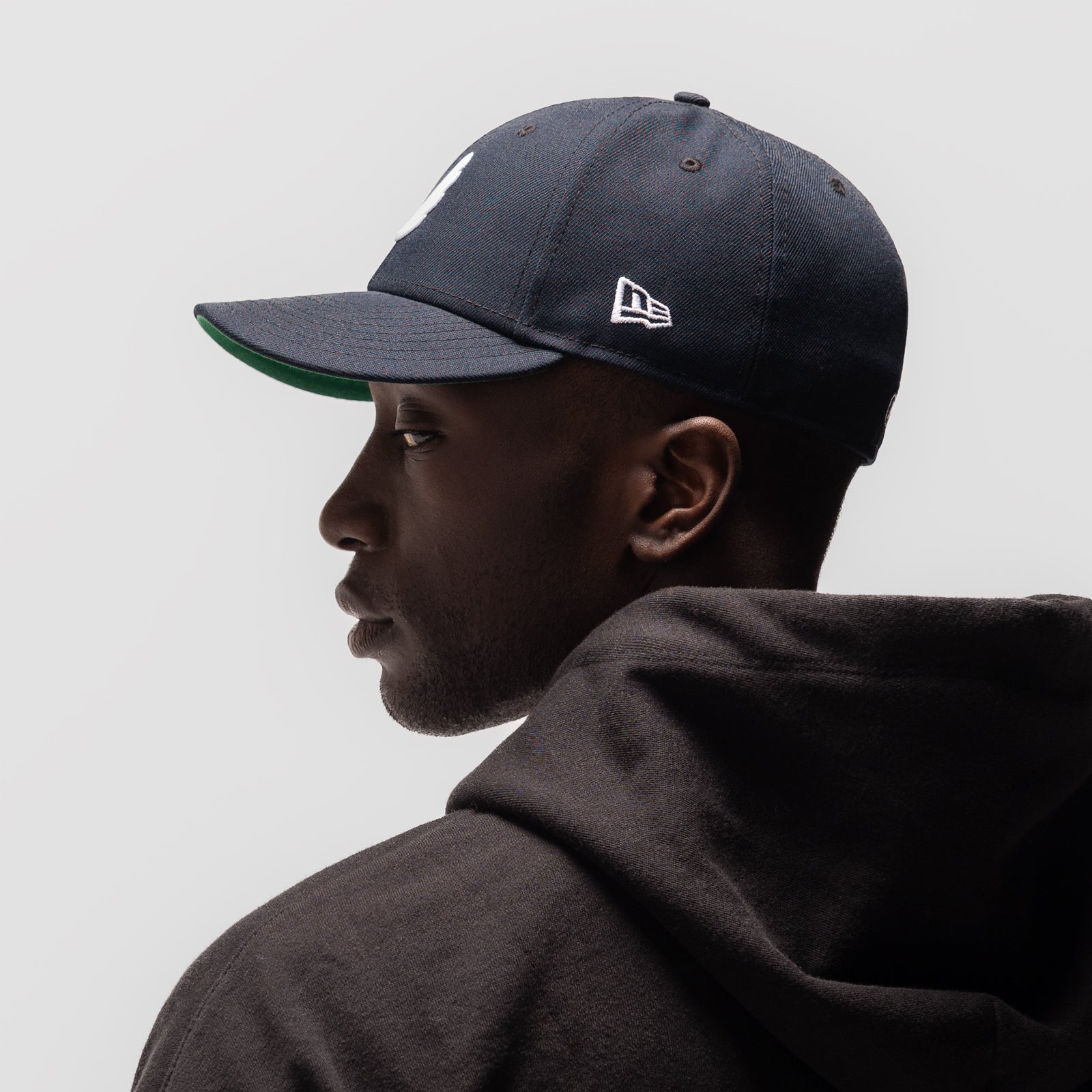 New Era 59Fifty Low Profile Hat in navy with white wings logo, worn by model in profile view