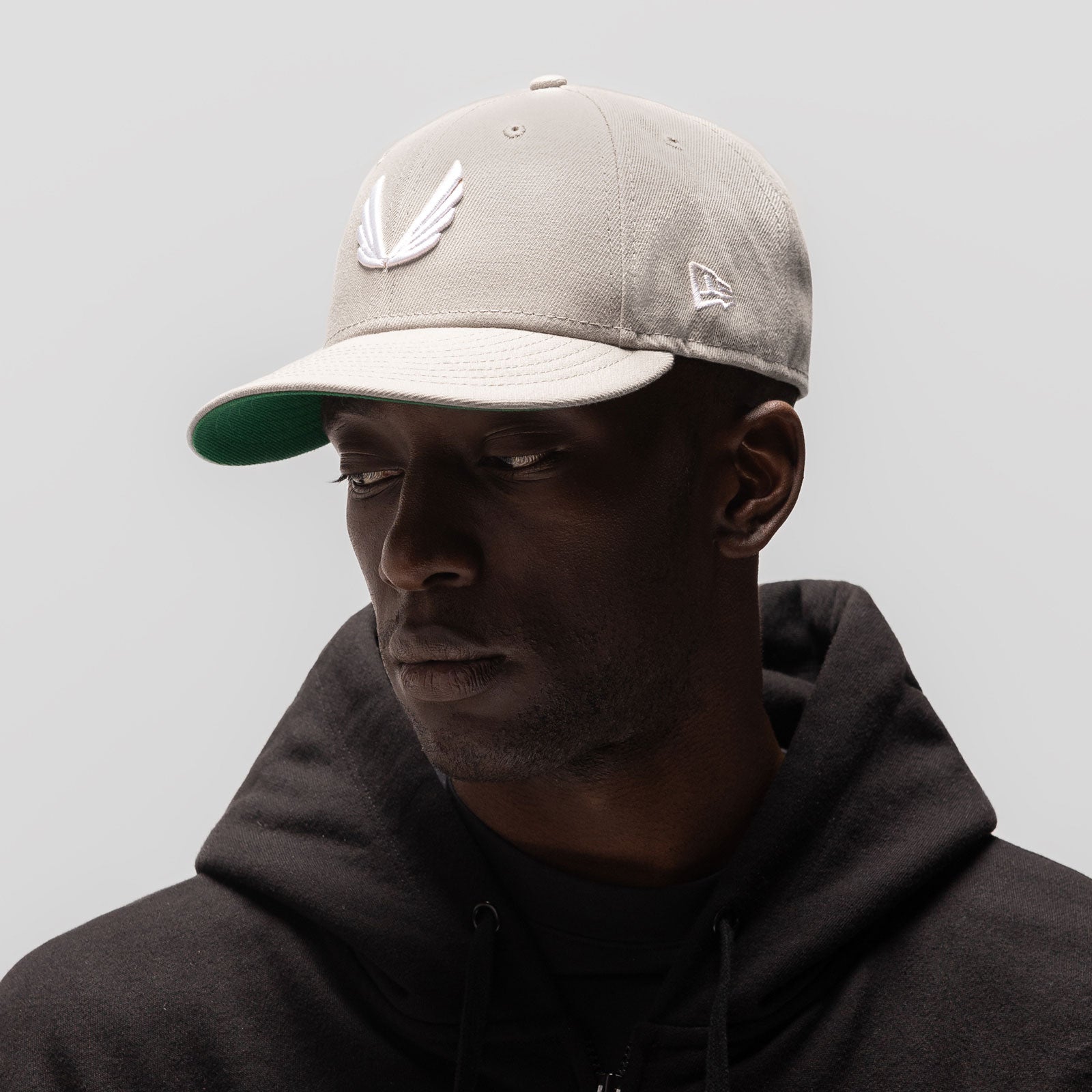 New Era 59Fifty Low Profile Hat in stone and white with wings logo, worn by model