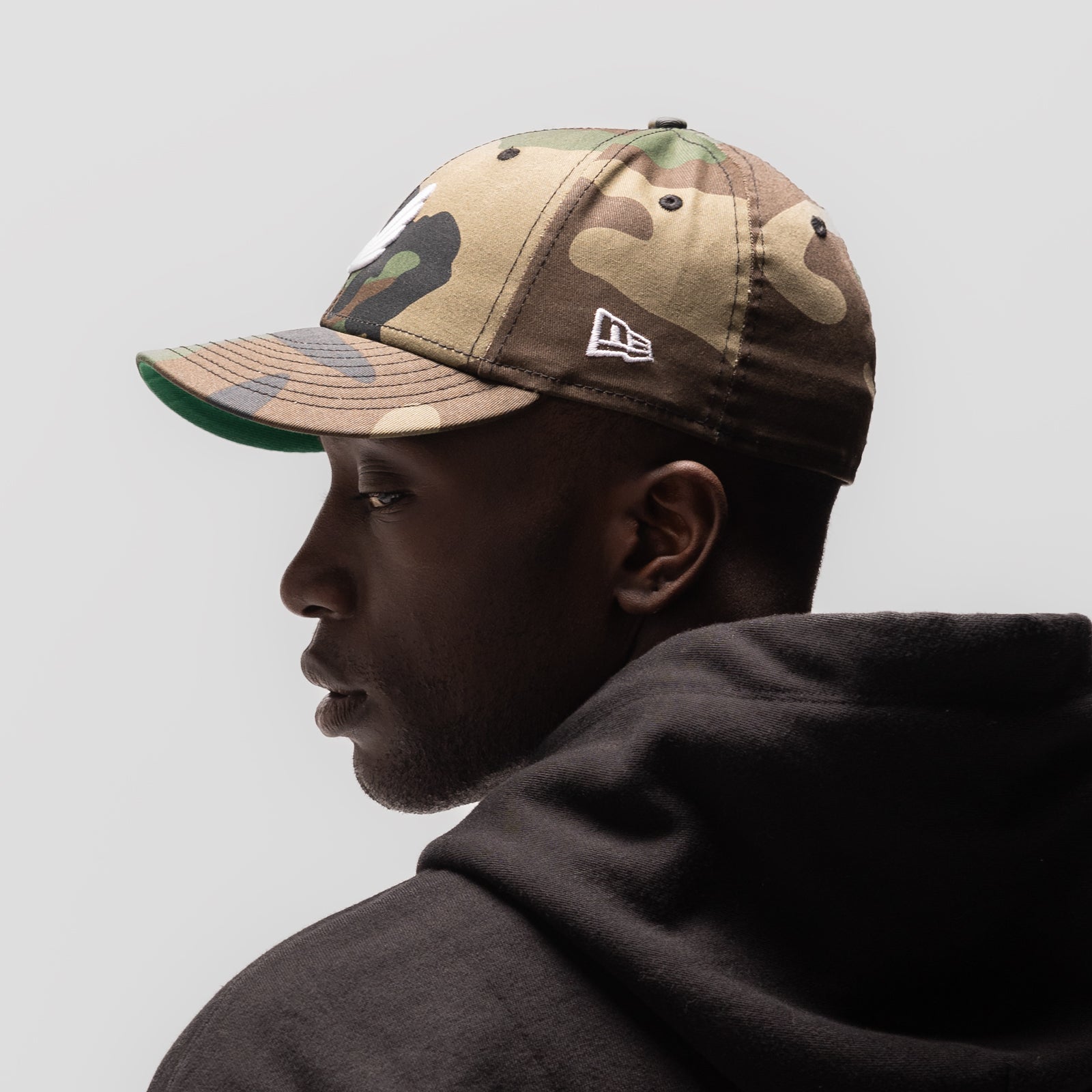 New Era 59Fifty Low Profile Hat in Woodland Camo with White Wings logo, worn by model in profile