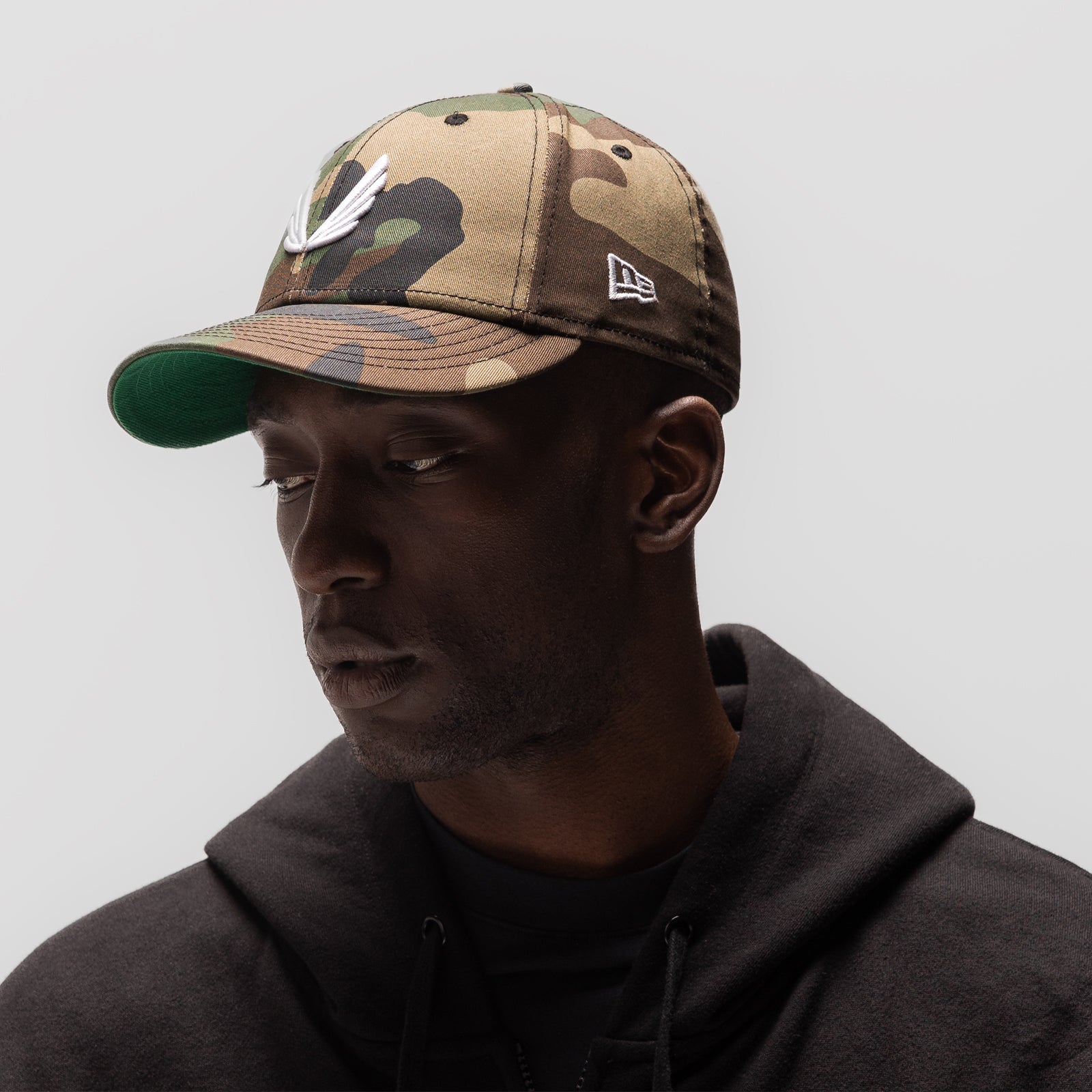 New Era 59Fifty Low Profile Hat in woodland camo with white wings logo, worn by model