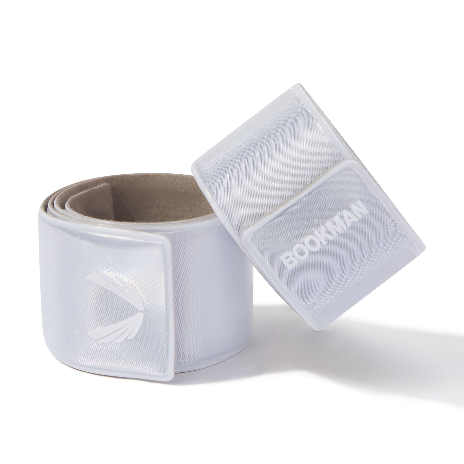 Flatlay of ASRV x Bookman Reflective Snap Band in white with packaging, overhead view