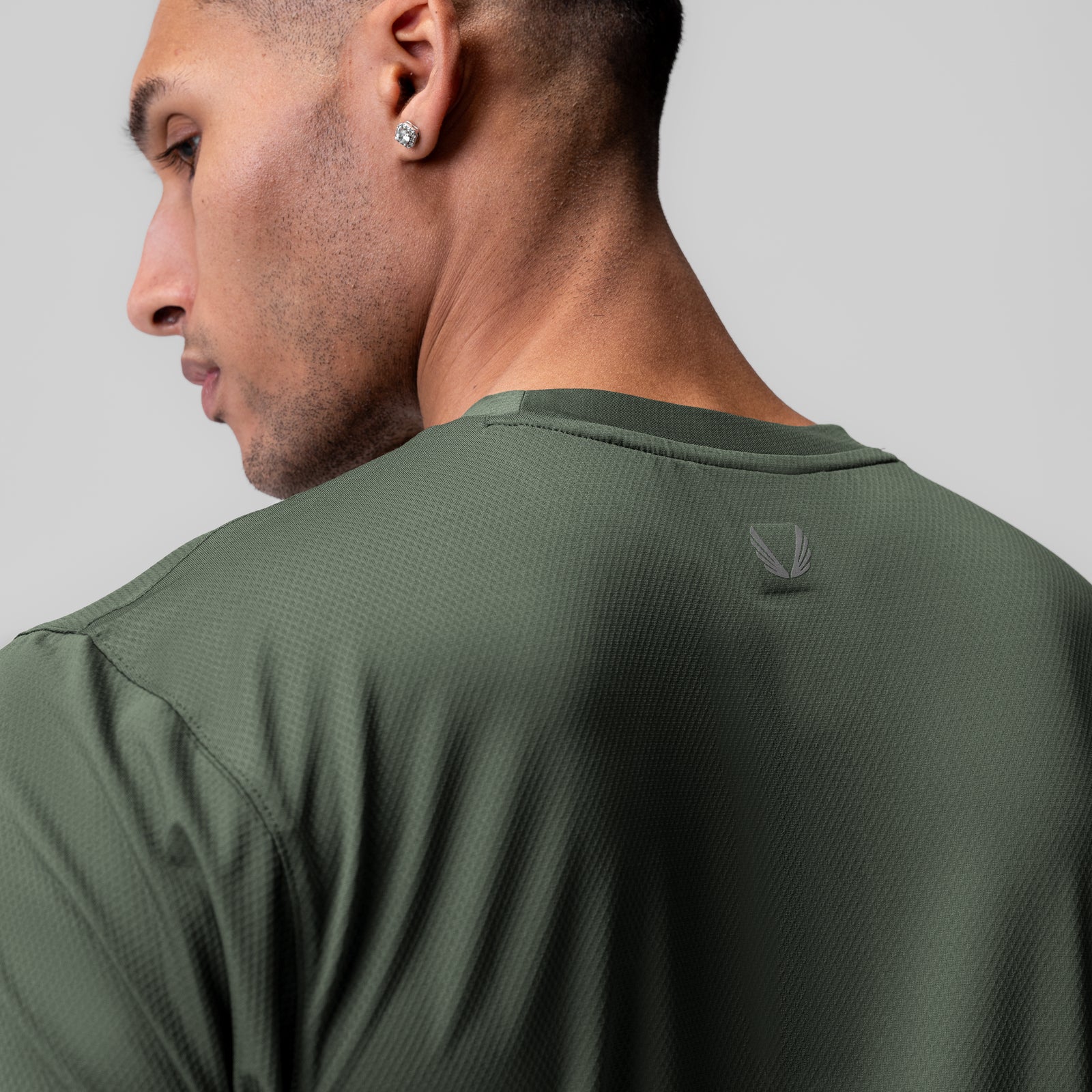 AeroSilver Essential Tee in olive, worn by model shown from side profile