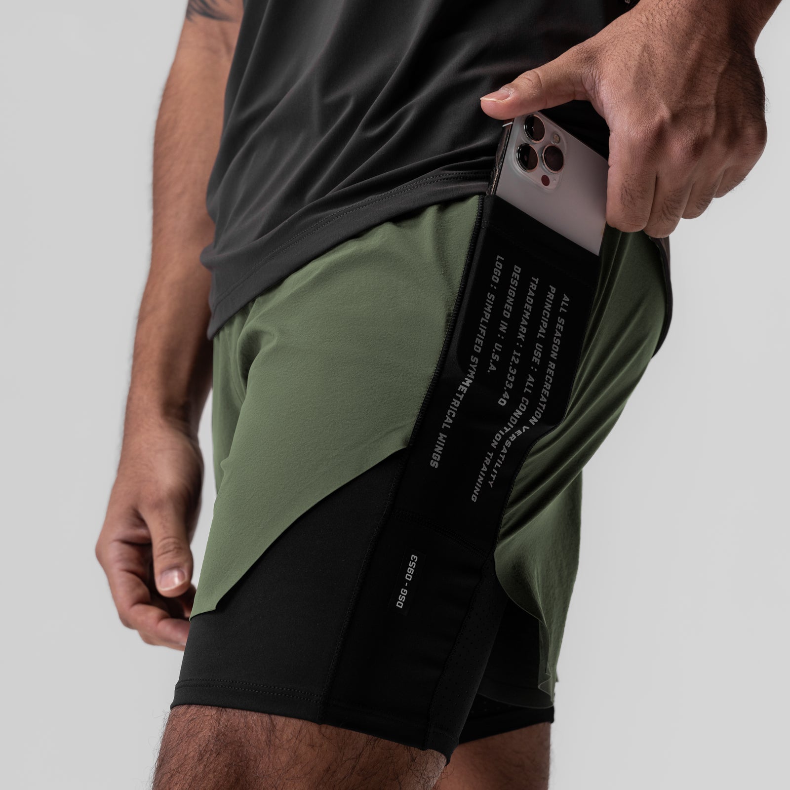 Aerotex™ Hybrid Liner Short in Olive/Black, model holding phone in pocket, side view