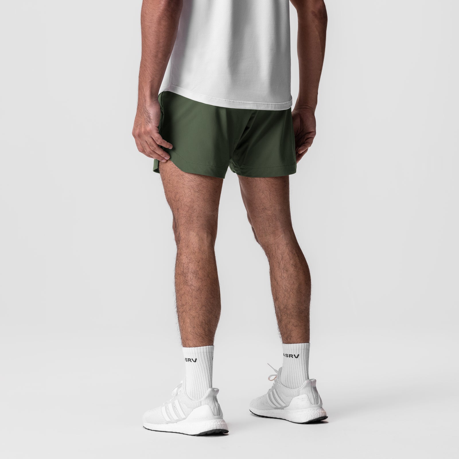 Tetra-Lite 5" Linerless Short in olive, worn by model from behind, paired with white socks and sneakers