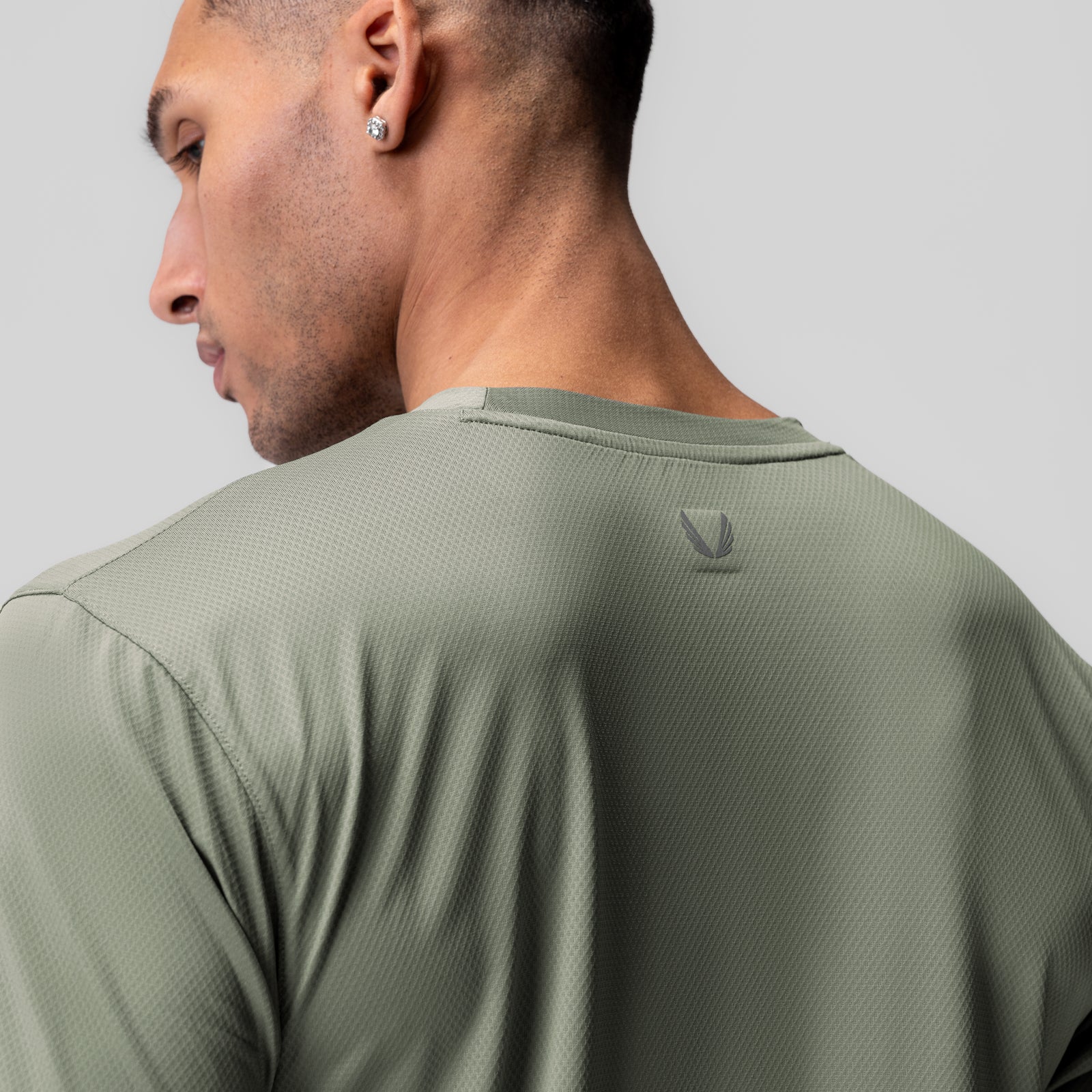 AeroSilver Essential Tee in sage worn by model, back view