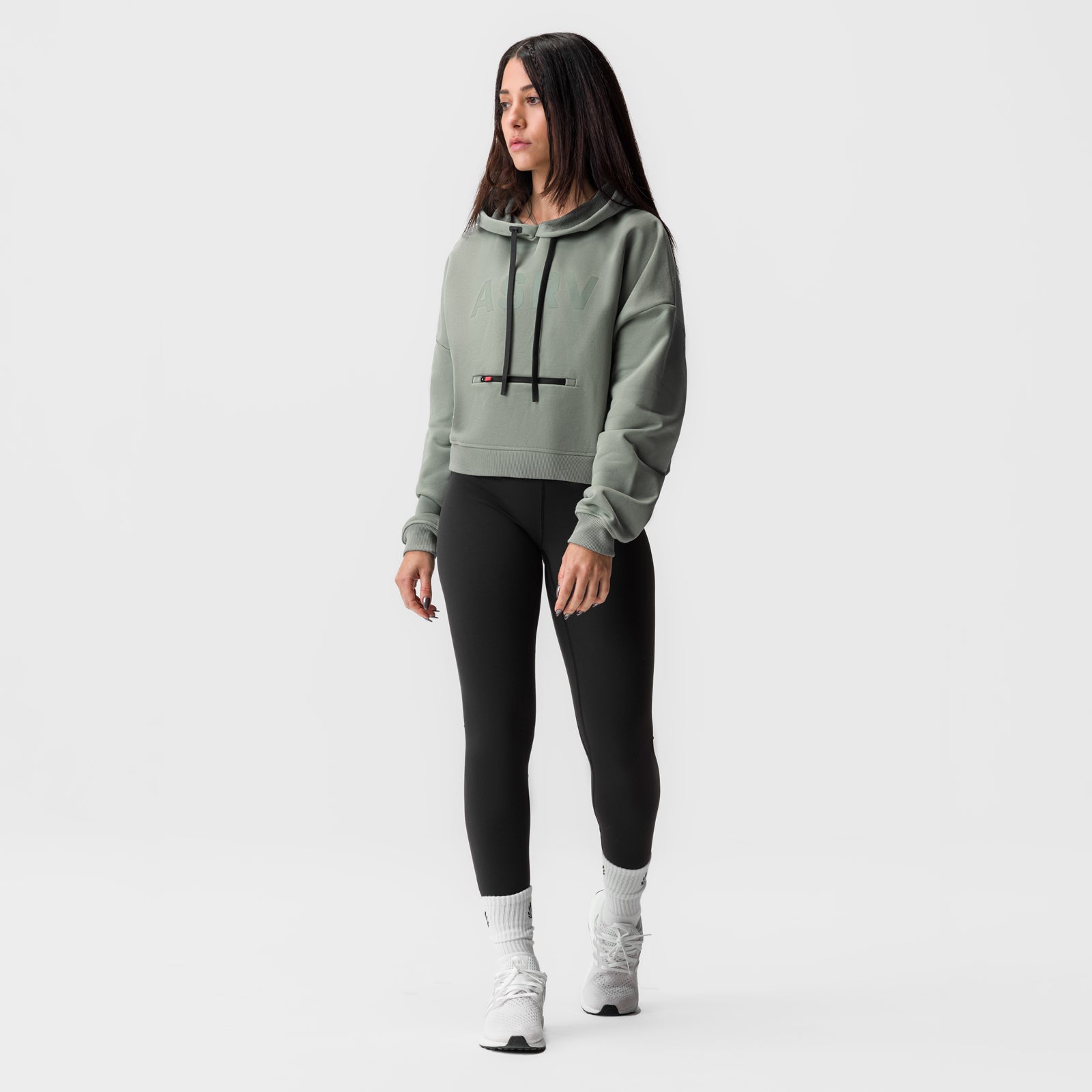 Sage cropped hoodie worn with black leggings and white socks, front view