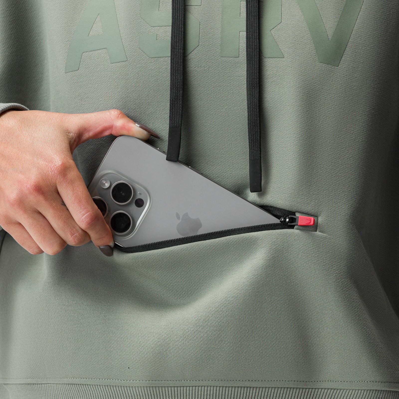 Sage cropped hoodie worn with hand holding iPhone in kangaroo pocket