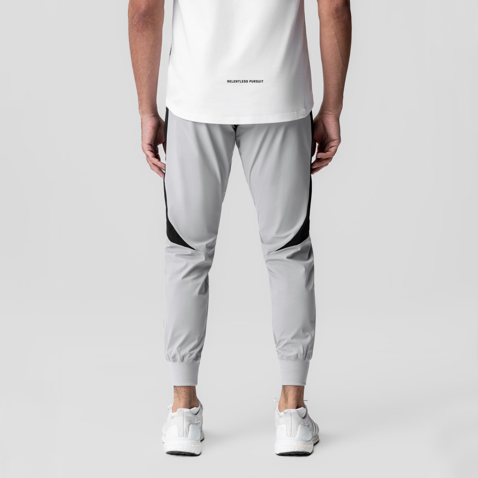 Slate grey cuffed training jogger with black side panels, back view on model