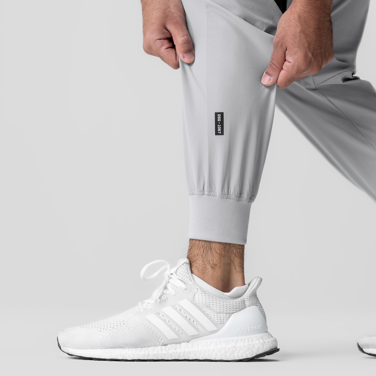 Slate grey cuffed training jogger worn with white sneakers, front view detail