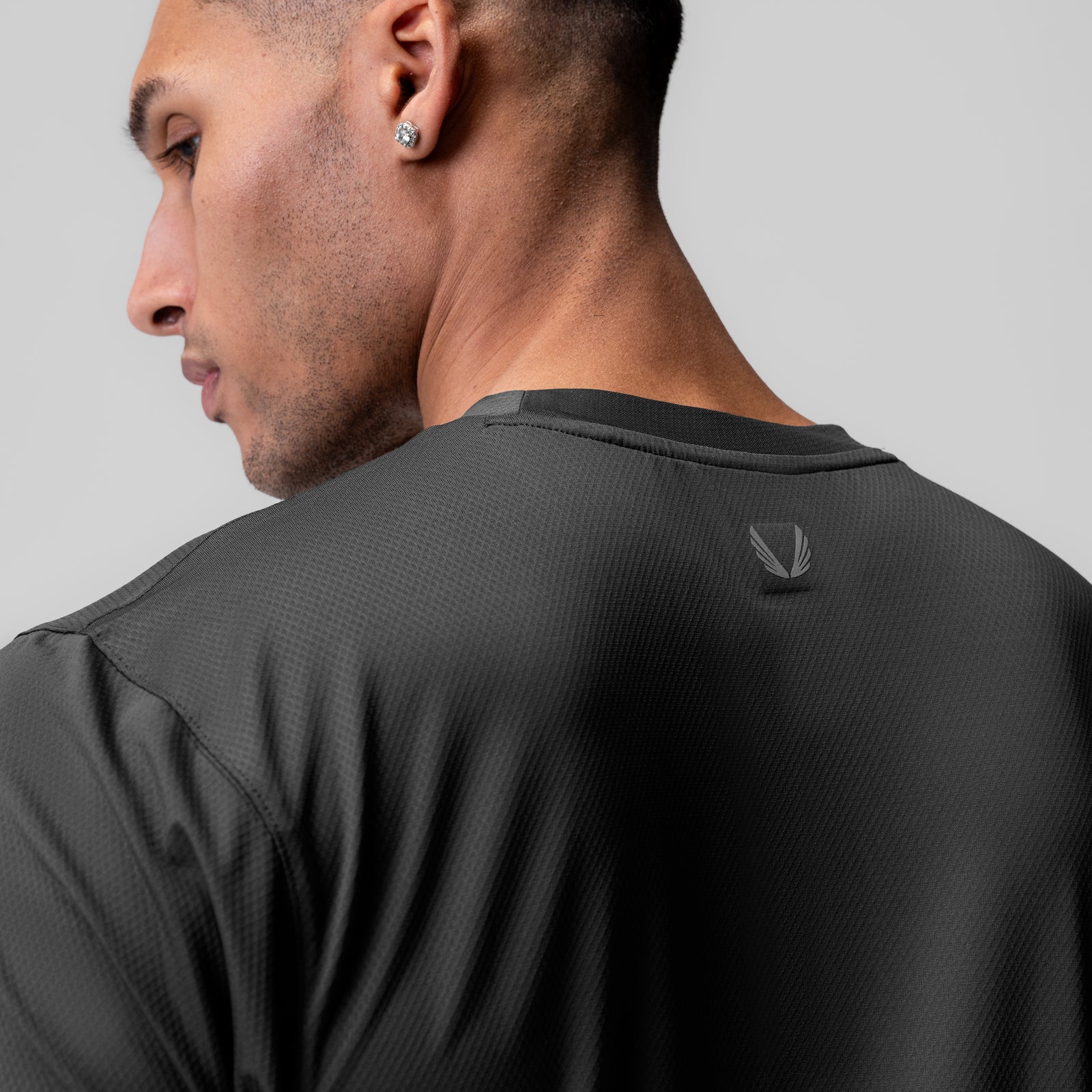 ASRV AeroSilver Essential Tee in Space Grey, worn by model in profile view