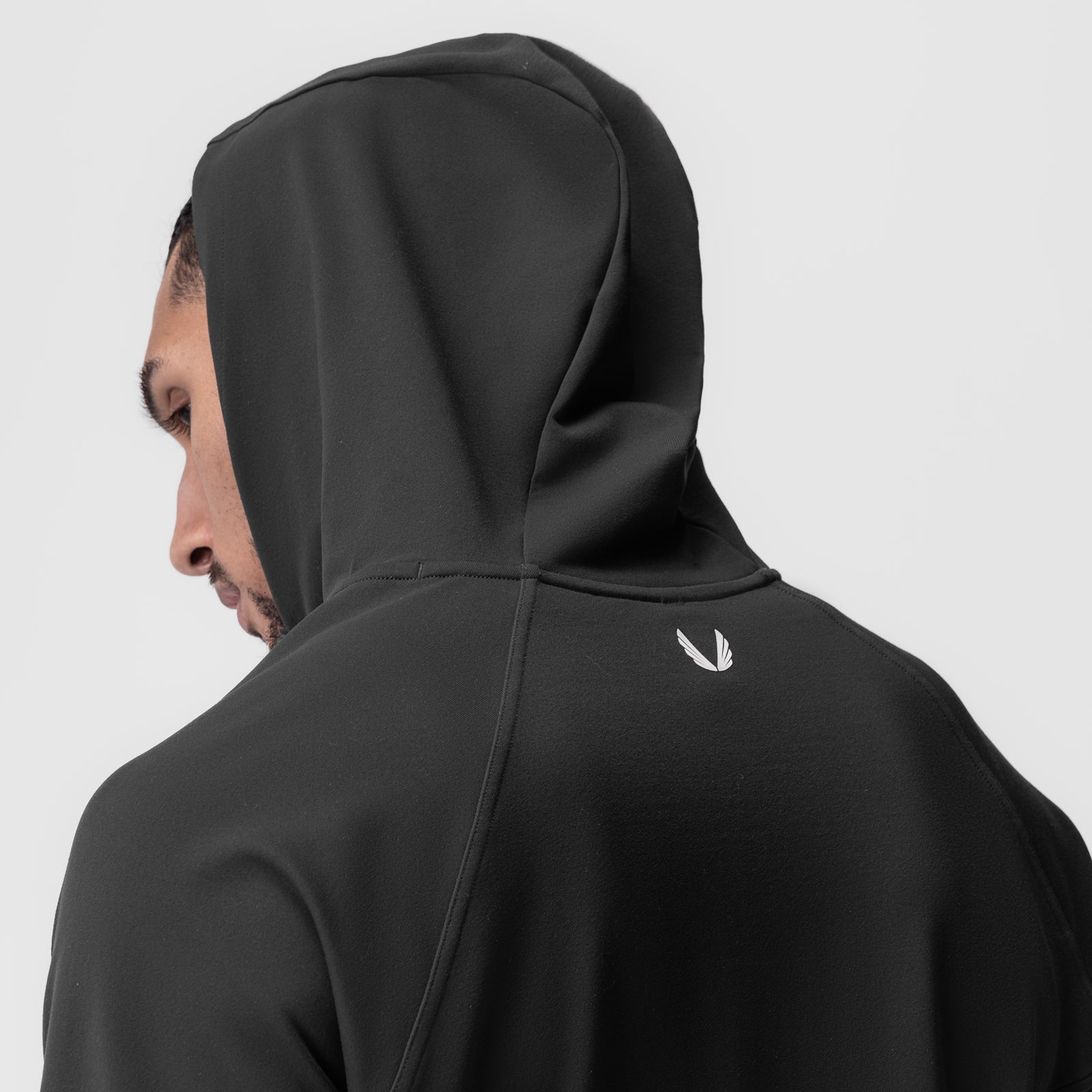 Performance Fleece Zip Hoodie in black, modeled from side profile with hood up