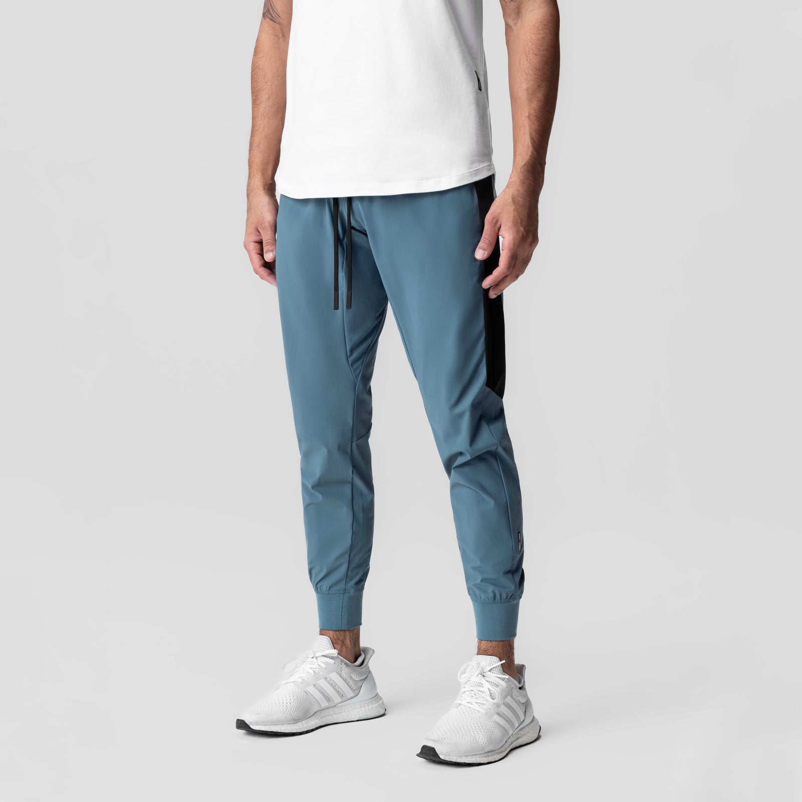 Tetra-Lite Cuffed Training Jogger in storm blue with black side stripe, worn by model