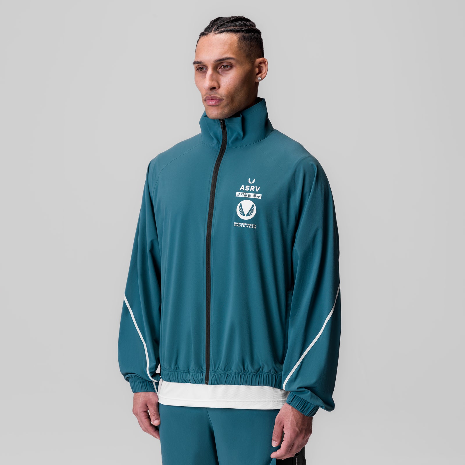 Aerotex Track Jacket in teal with white trim, worn by model facing forward