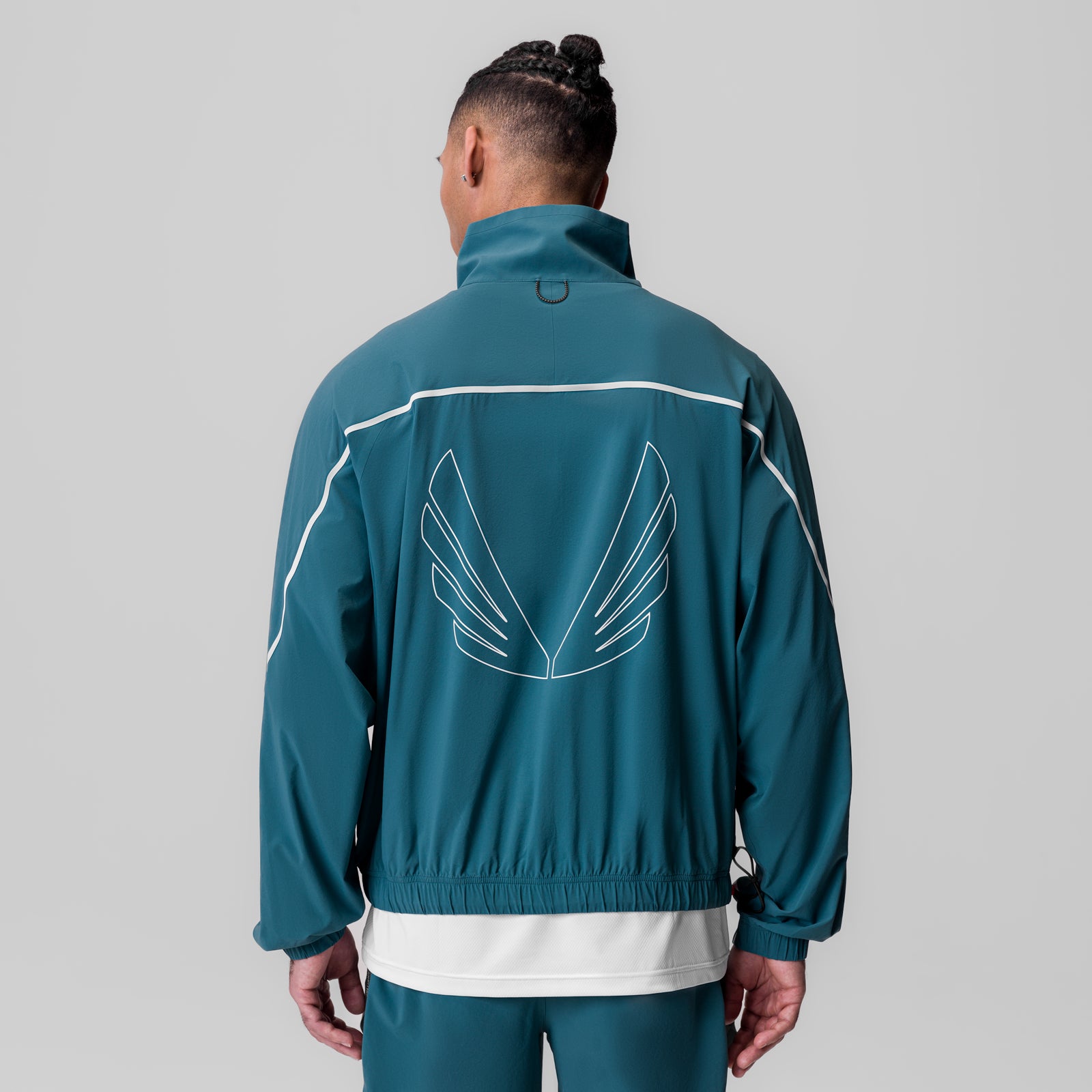 Aerotex™ Track Jacket in storm teal with white stripes, worn by model showing back view with wing graphic