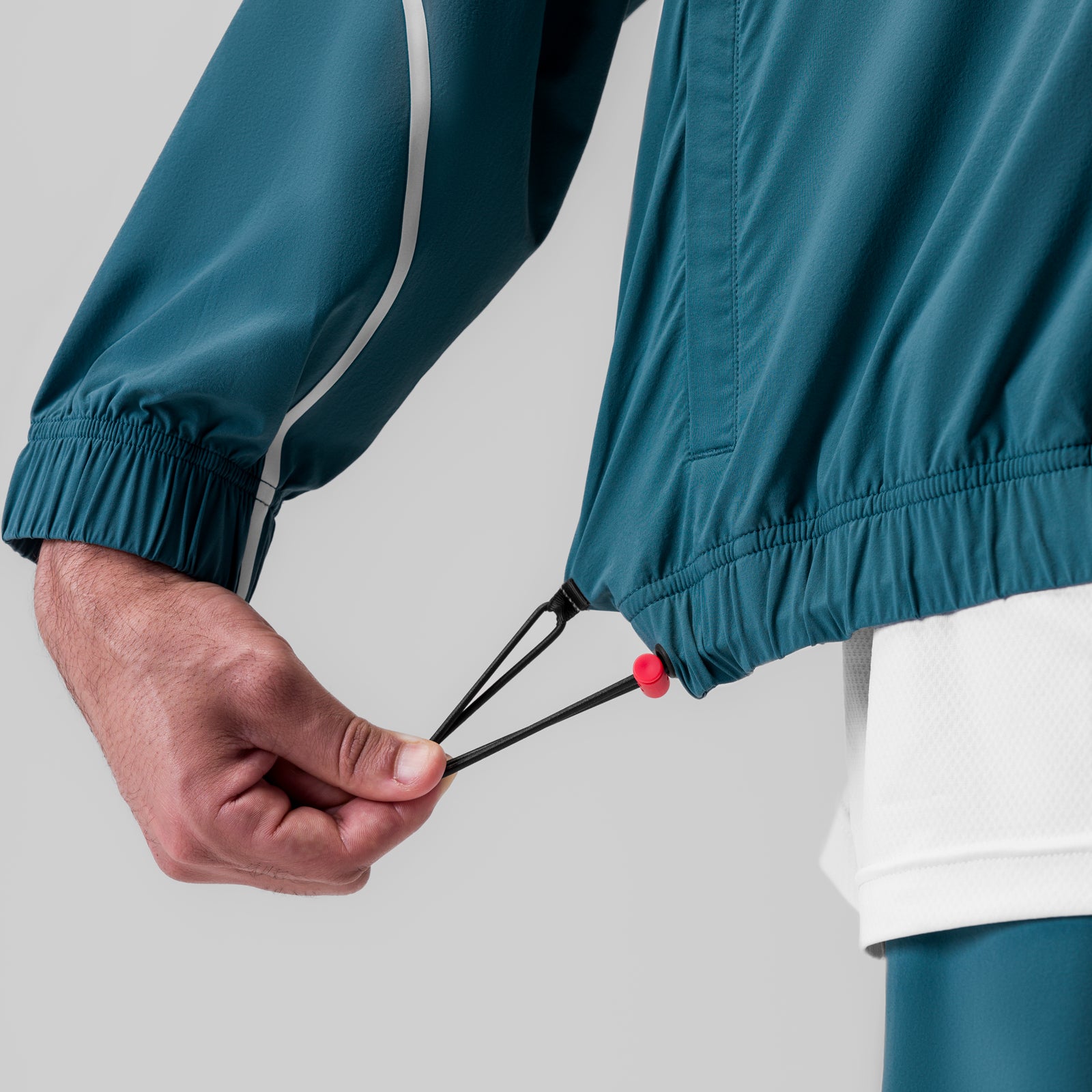 Aerotex Track Jacket in Storm blue being worn, detail of adjustable cuff and drawstring