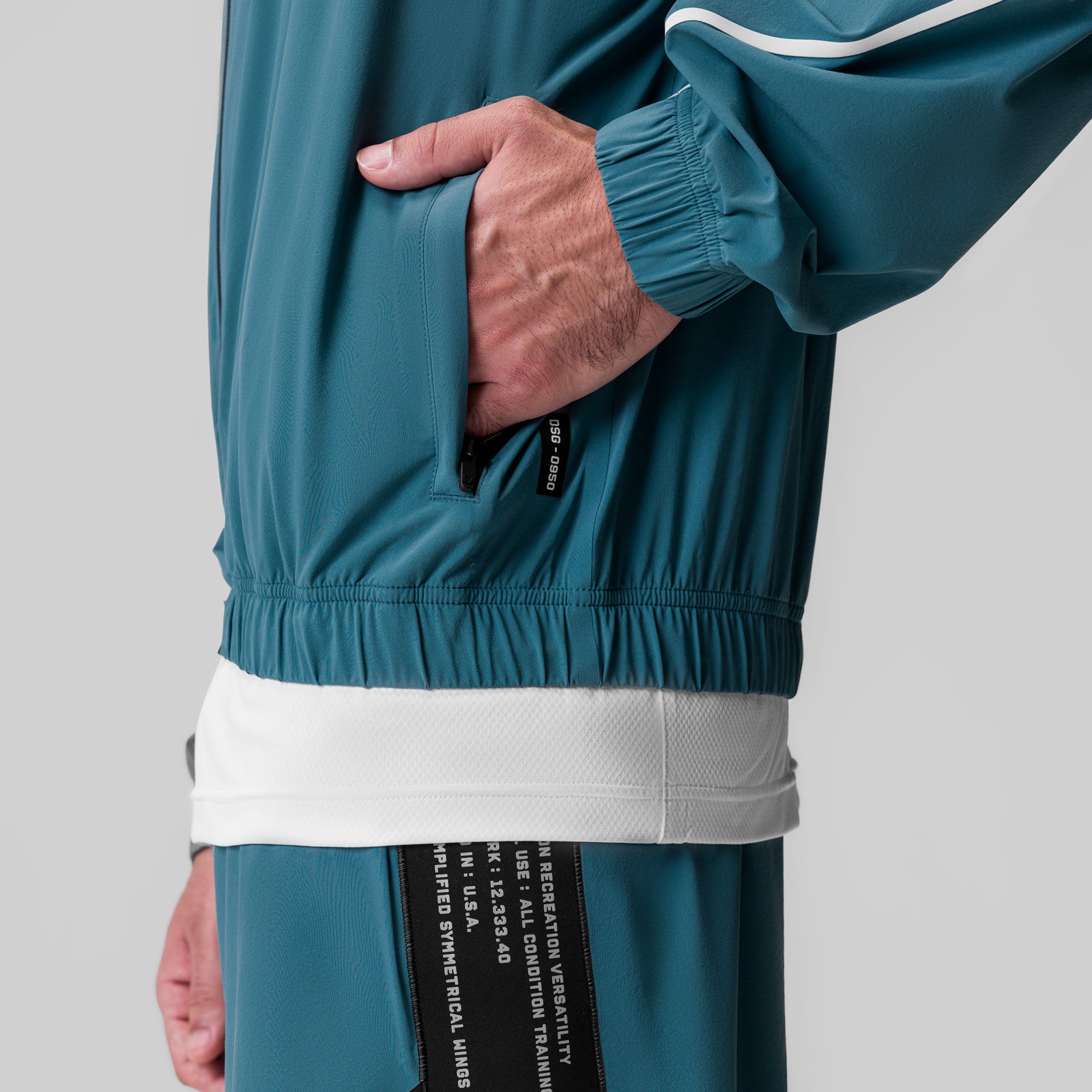 Aerotex Track Jacket in storm blue with white stripe, worn by model showing side pocket detail