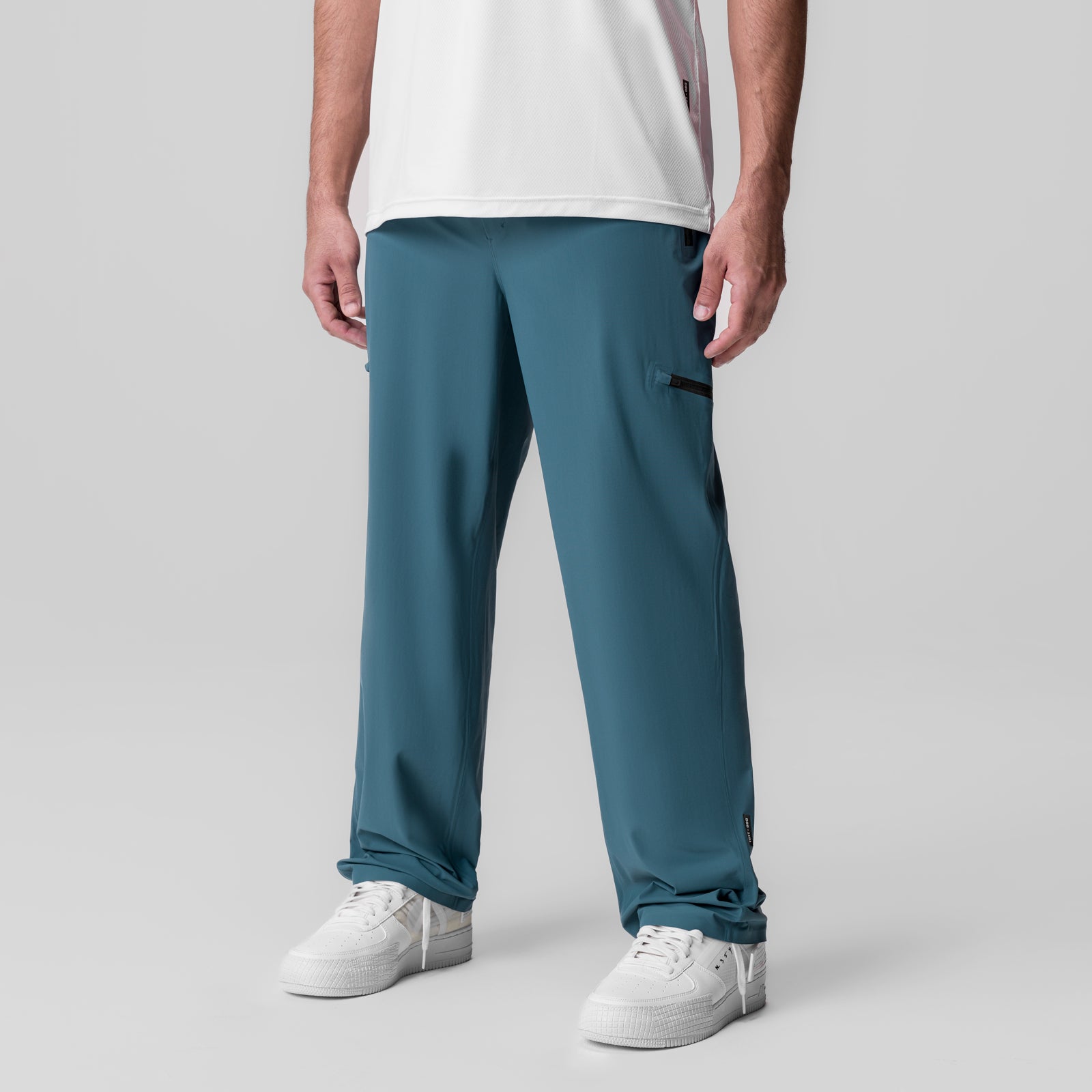 Tetra-Lite Field Pant in Storm blue worn by model with white sneakers, front view