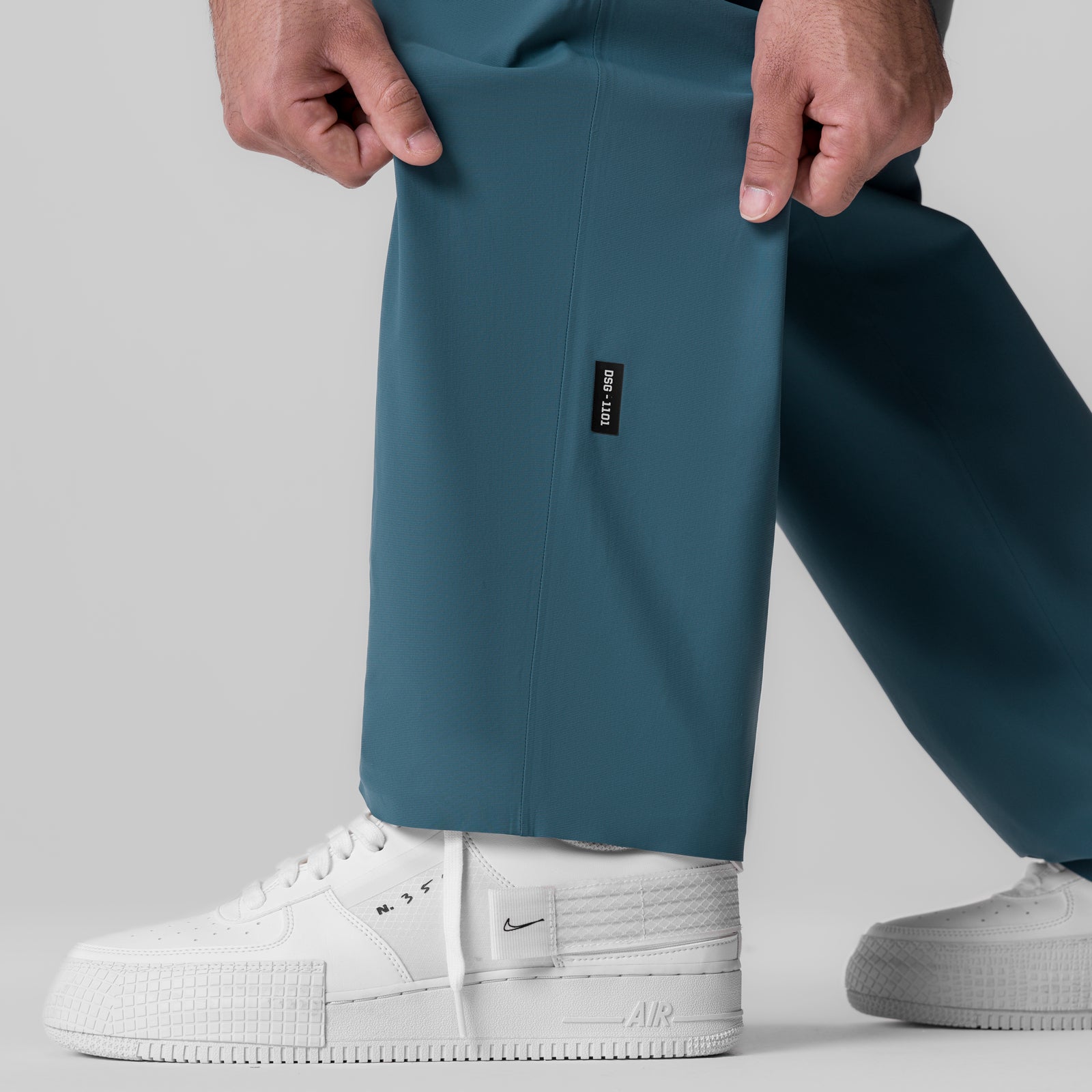 Tetra-Lite Field Pant in storm blue worn with white sneakers, front view