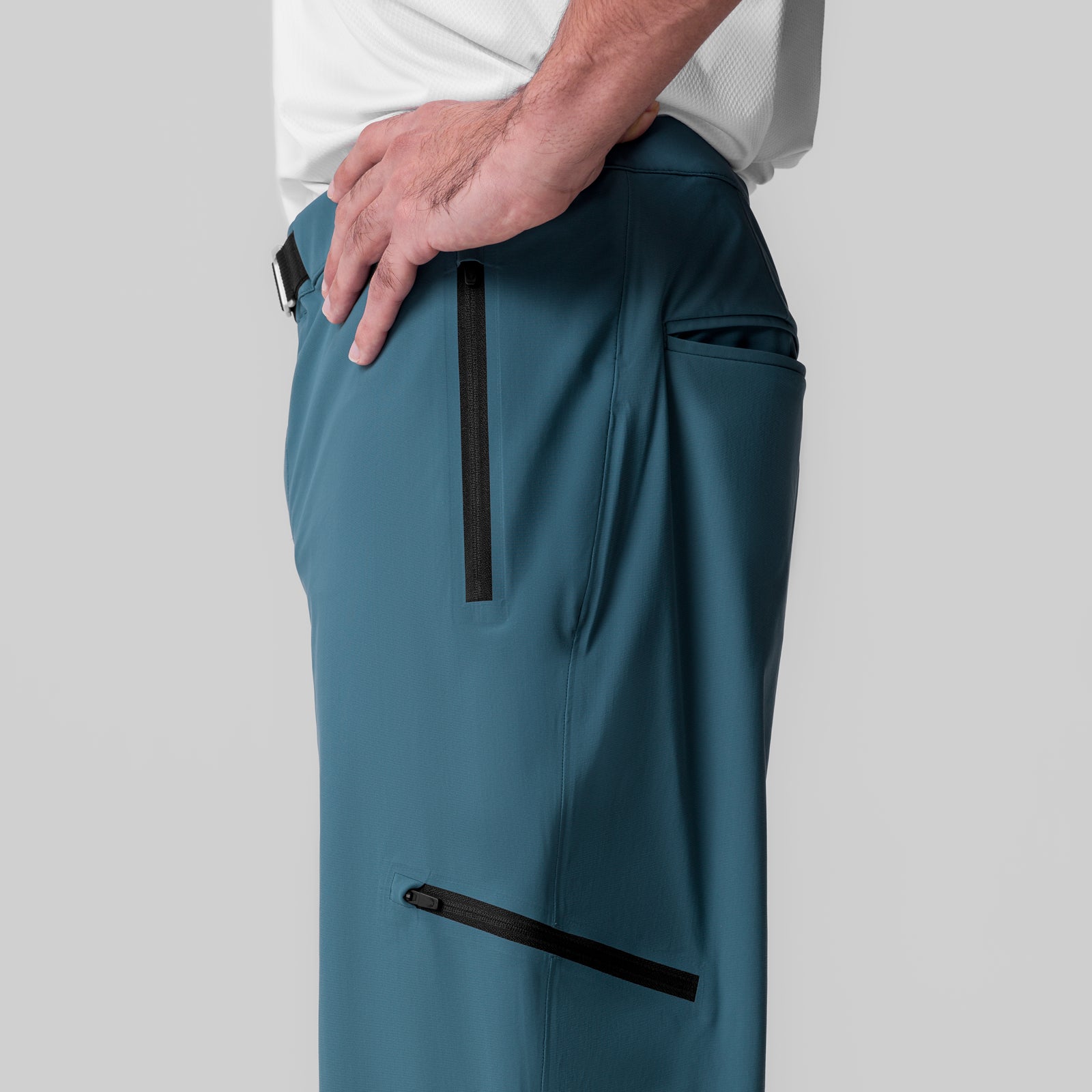 Tetra-Lite Field Pant in storm blue worn by model, side view showing zip pockets