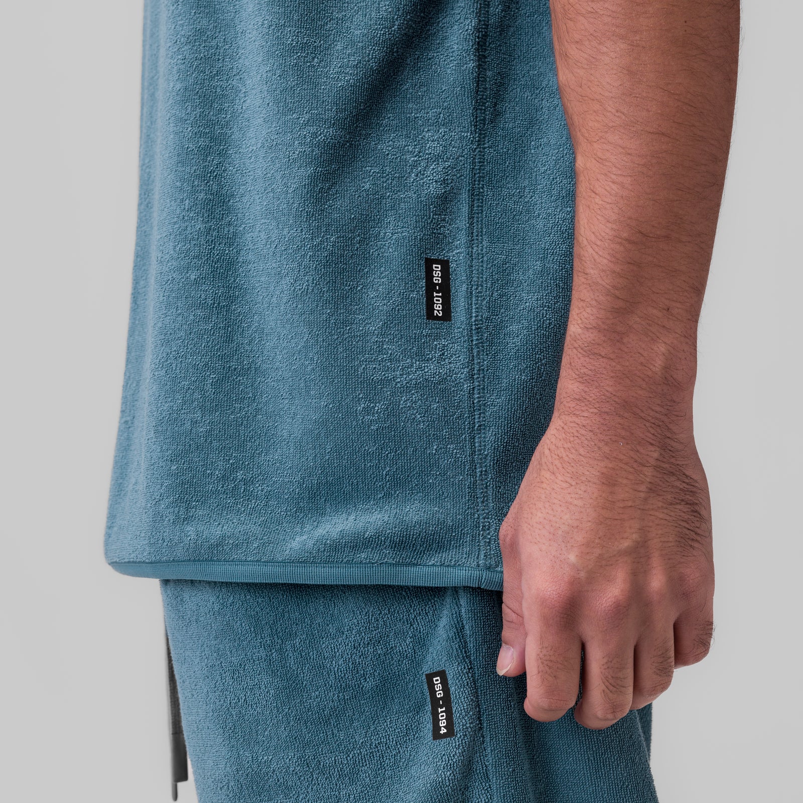 Towel Terry Cutoff in storm blue worn by model, side detail view showing label