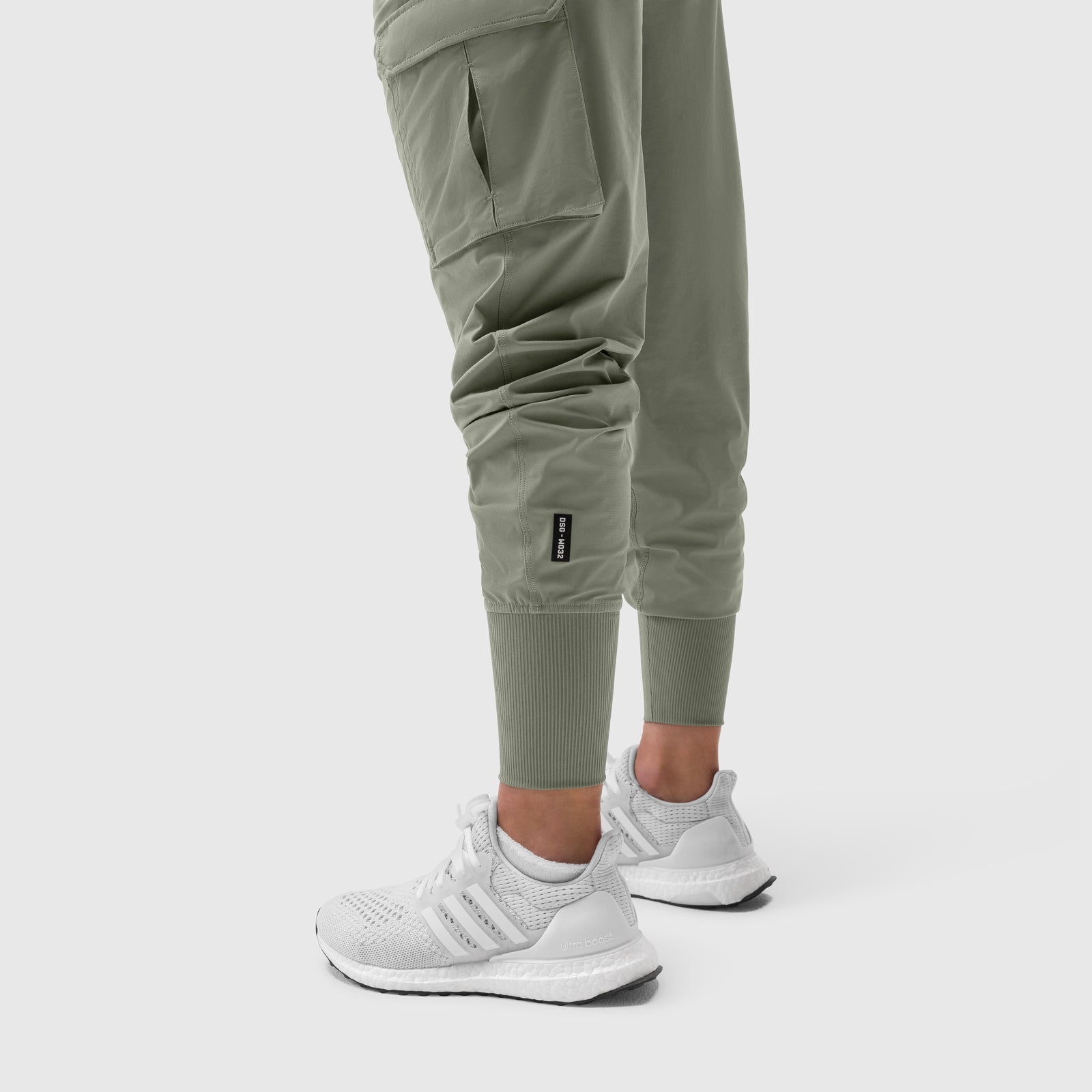 Tetra-Lite Cargo High Rib Jogger in sage worn with white sneakers, front leg detail view