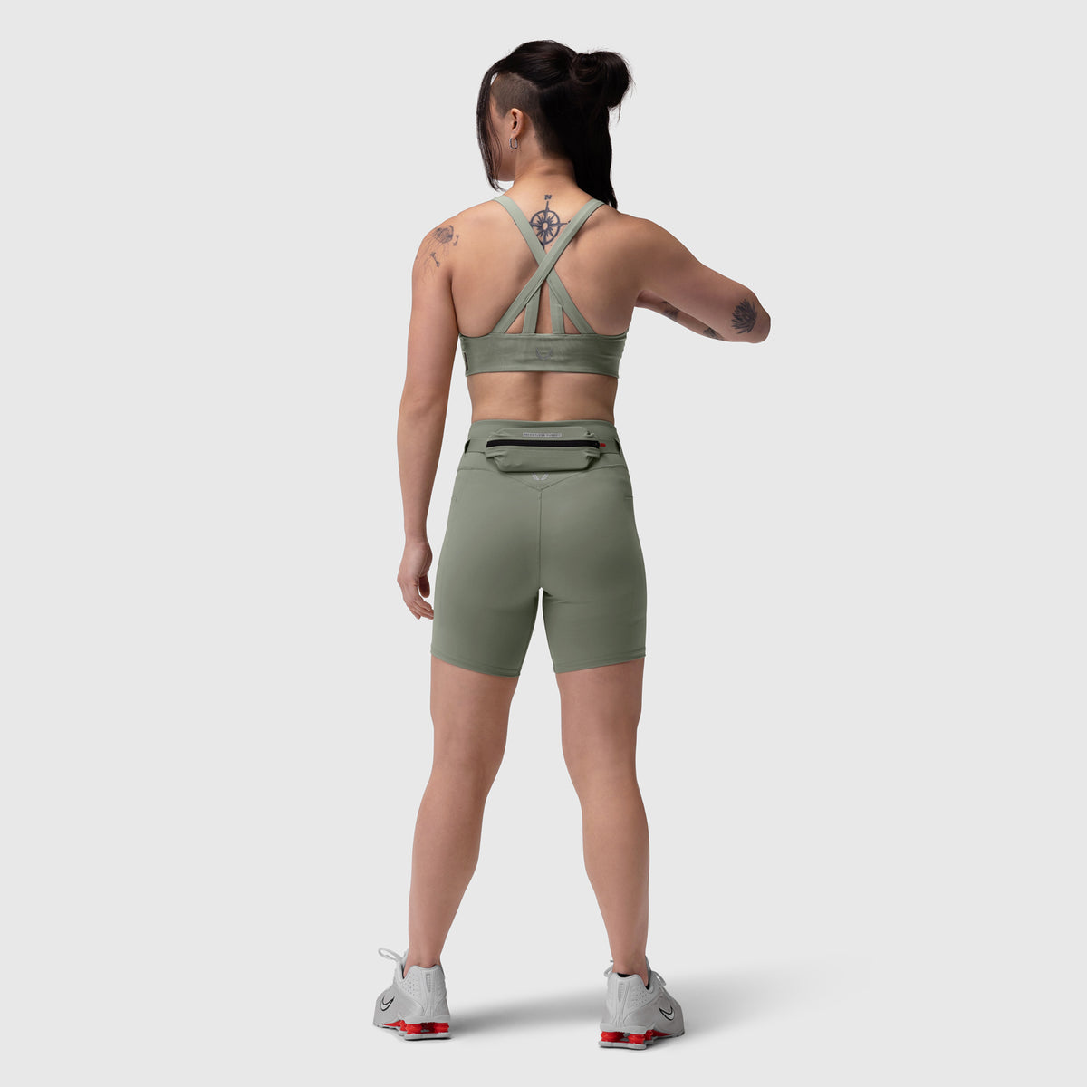 Lycra 3-in-1 biker short in sage, worn by model from back view showing cross-back sports bra