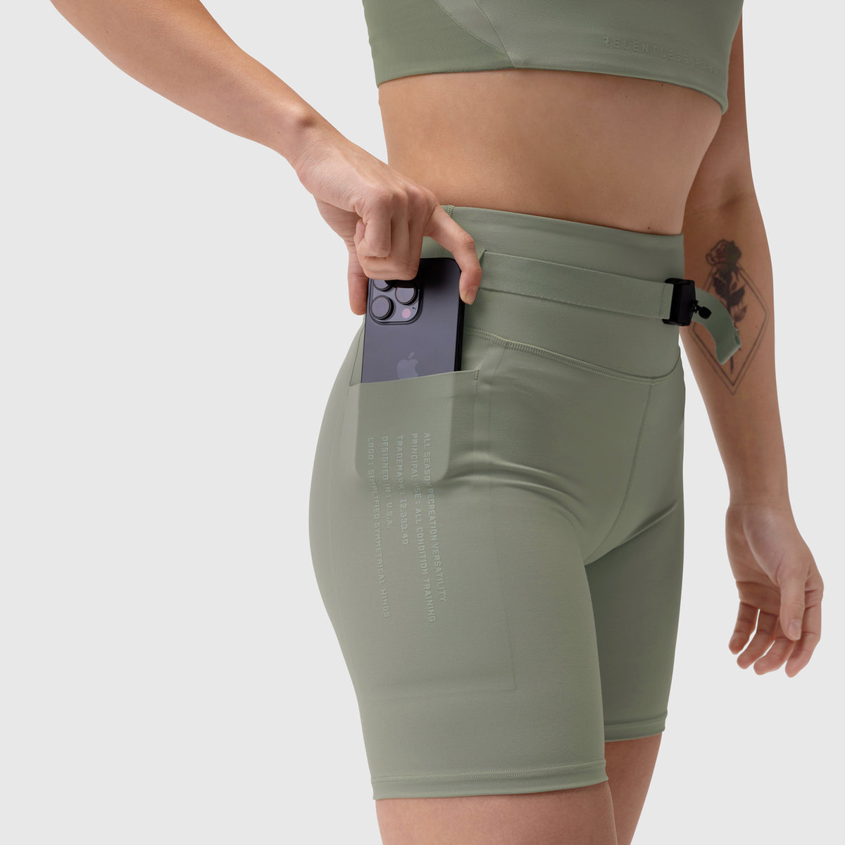 Lycra 3-in-1 Biker Short in sage, model wearing and retrieving phone from pocket
