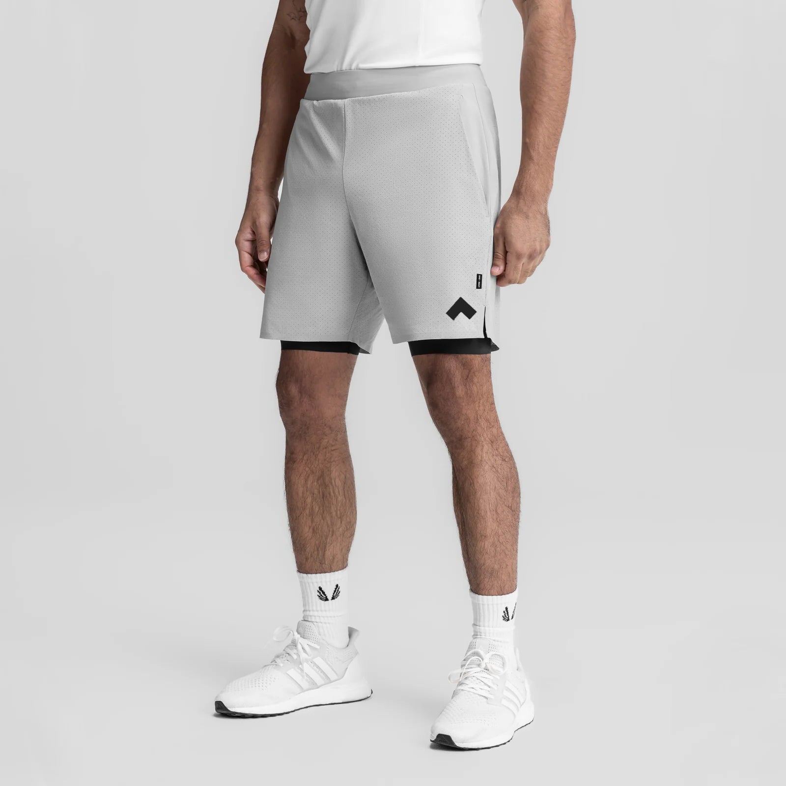 Slate grey bonded liner shorts with black trim on model wearing white sneakers, front view