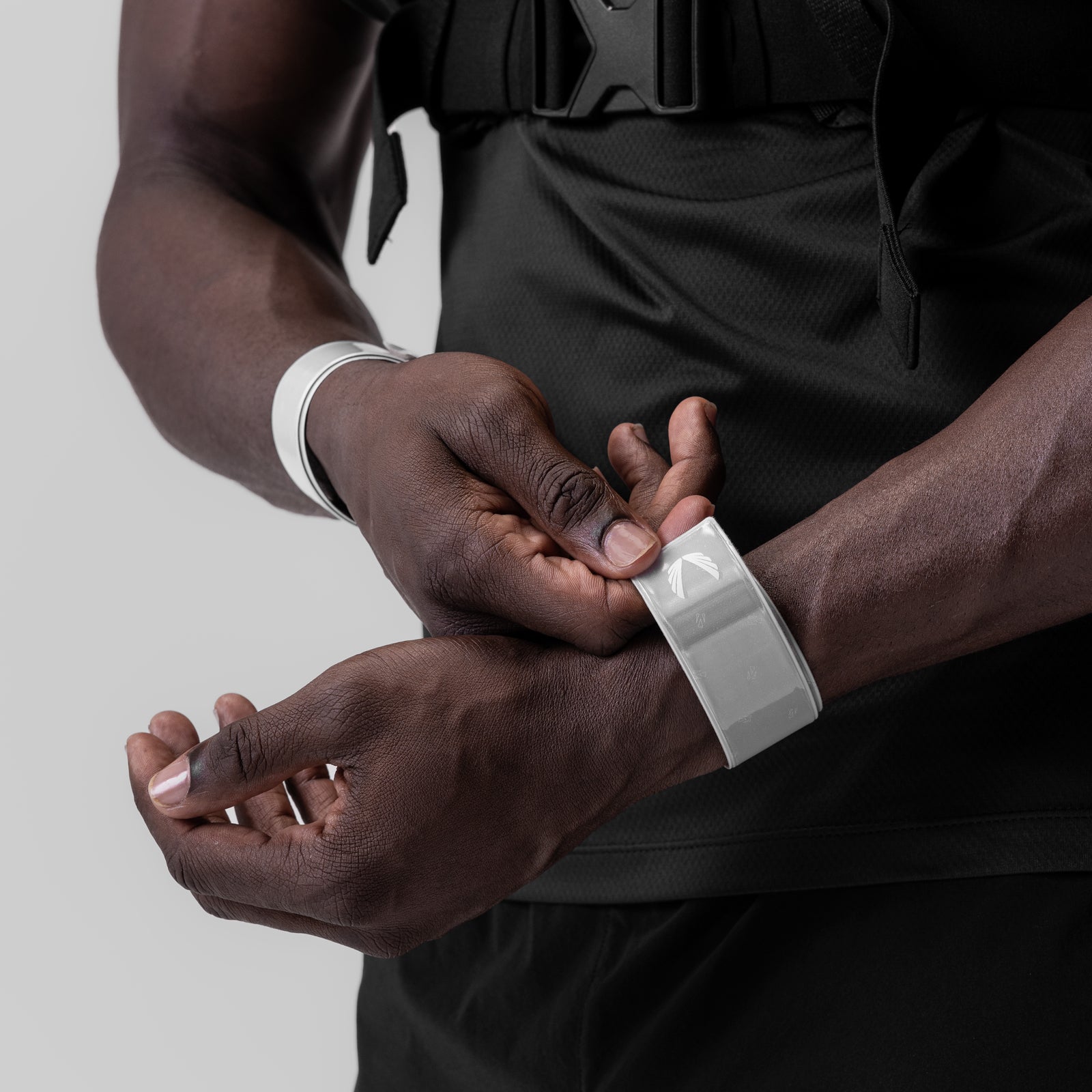 ASRV x Bookman Reflective Snap Band in white, worn on wrist