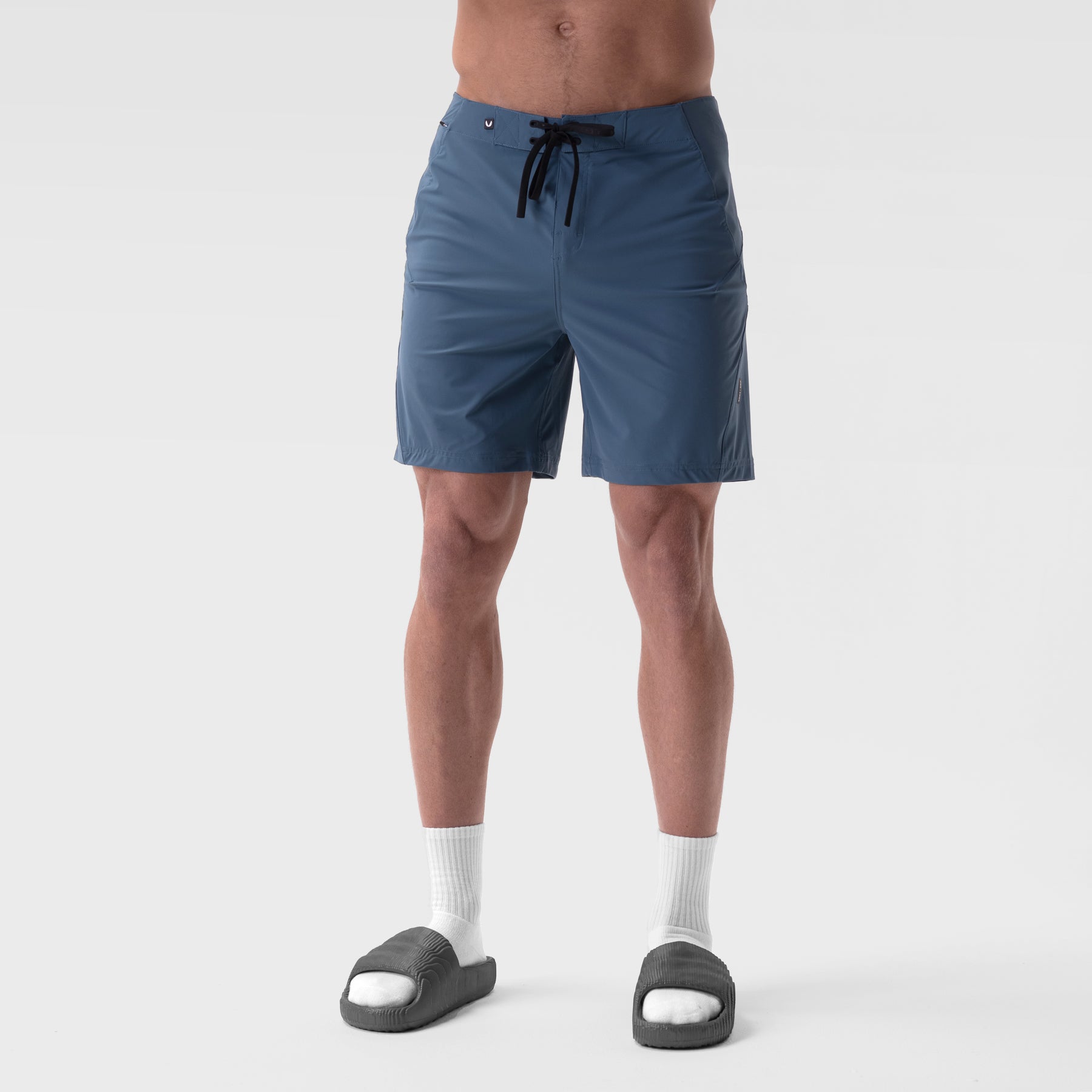 Revolutional Board Short in storm blue, worn by model with white socks and dark slides, front view