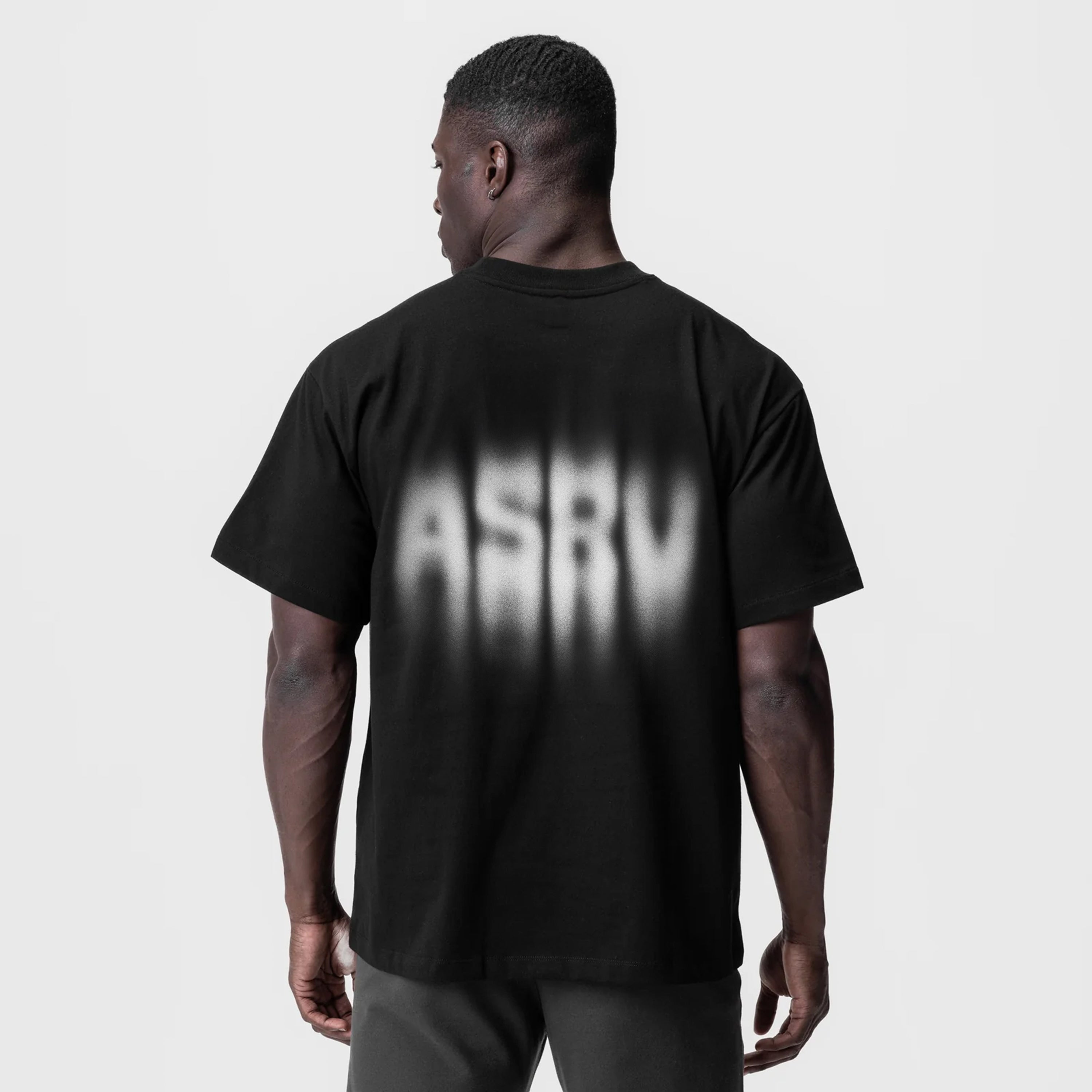 Tech Essential Relaxed Tee in black with motion blur graphic, worn by model, back view