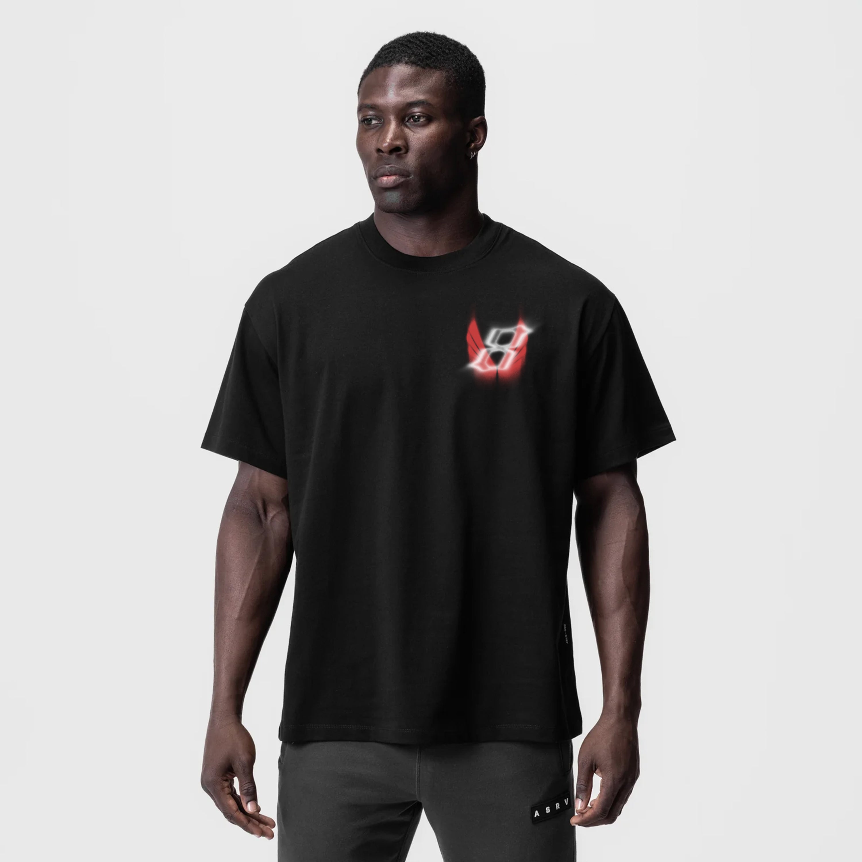 Black Tech Essential Relaxed Tee with red neon logo, worn by model, front view
