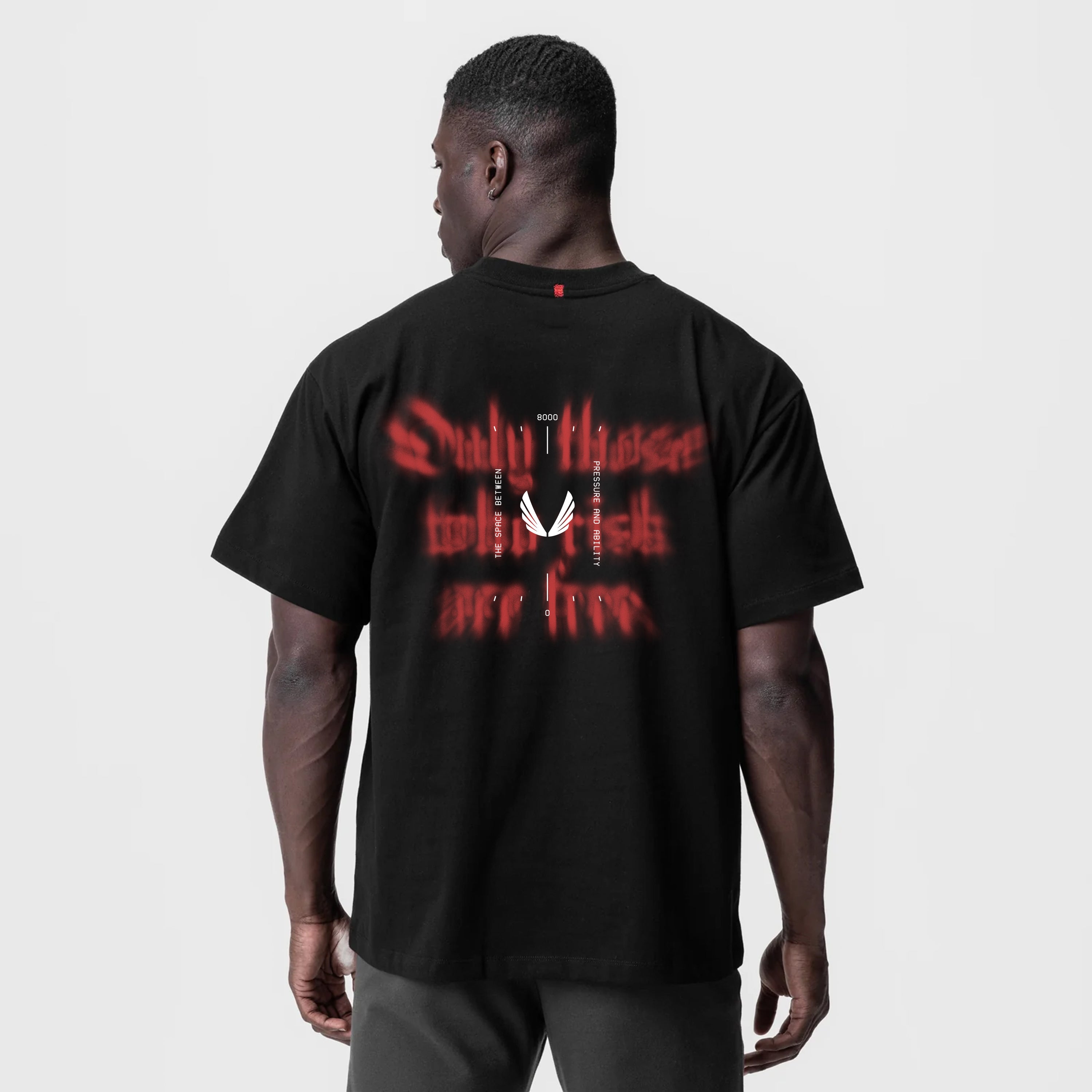 Black Tech Essential Relaxed Tee with red graphic print, back view on model
