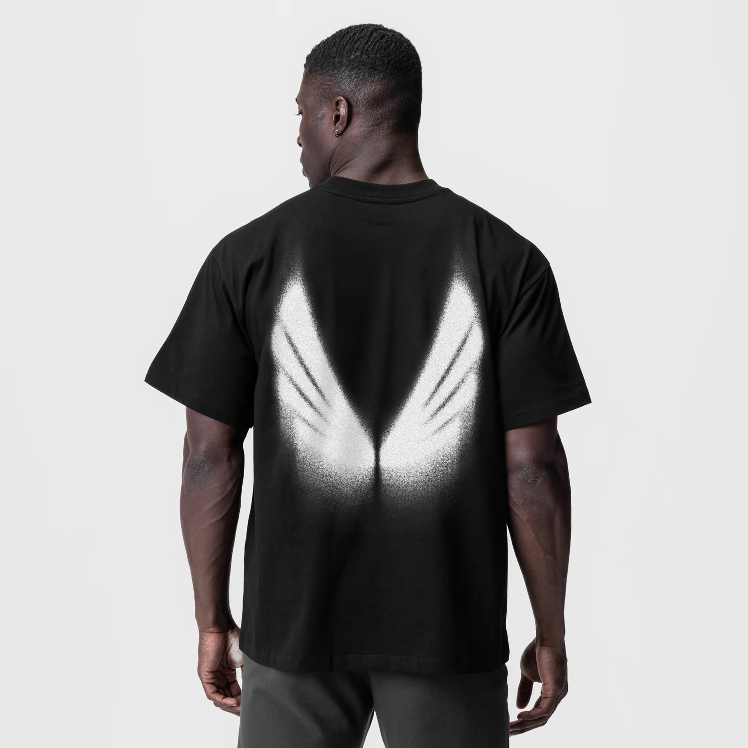 Black Tech Essential Relaxed Tee with white graphic design, back view on model