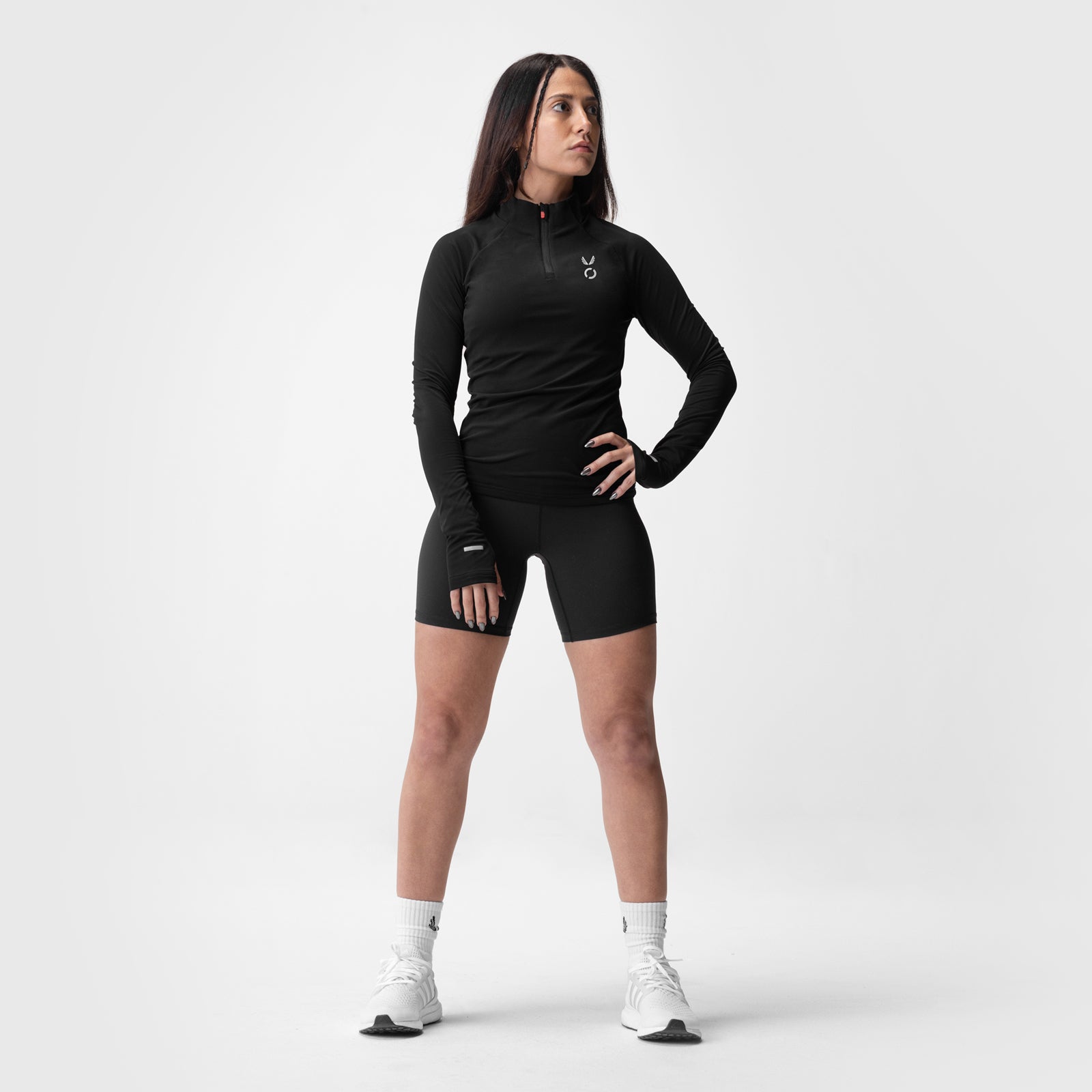 Performance Quarter Zip in black with matching shorts, worn by model standing against neutral background
