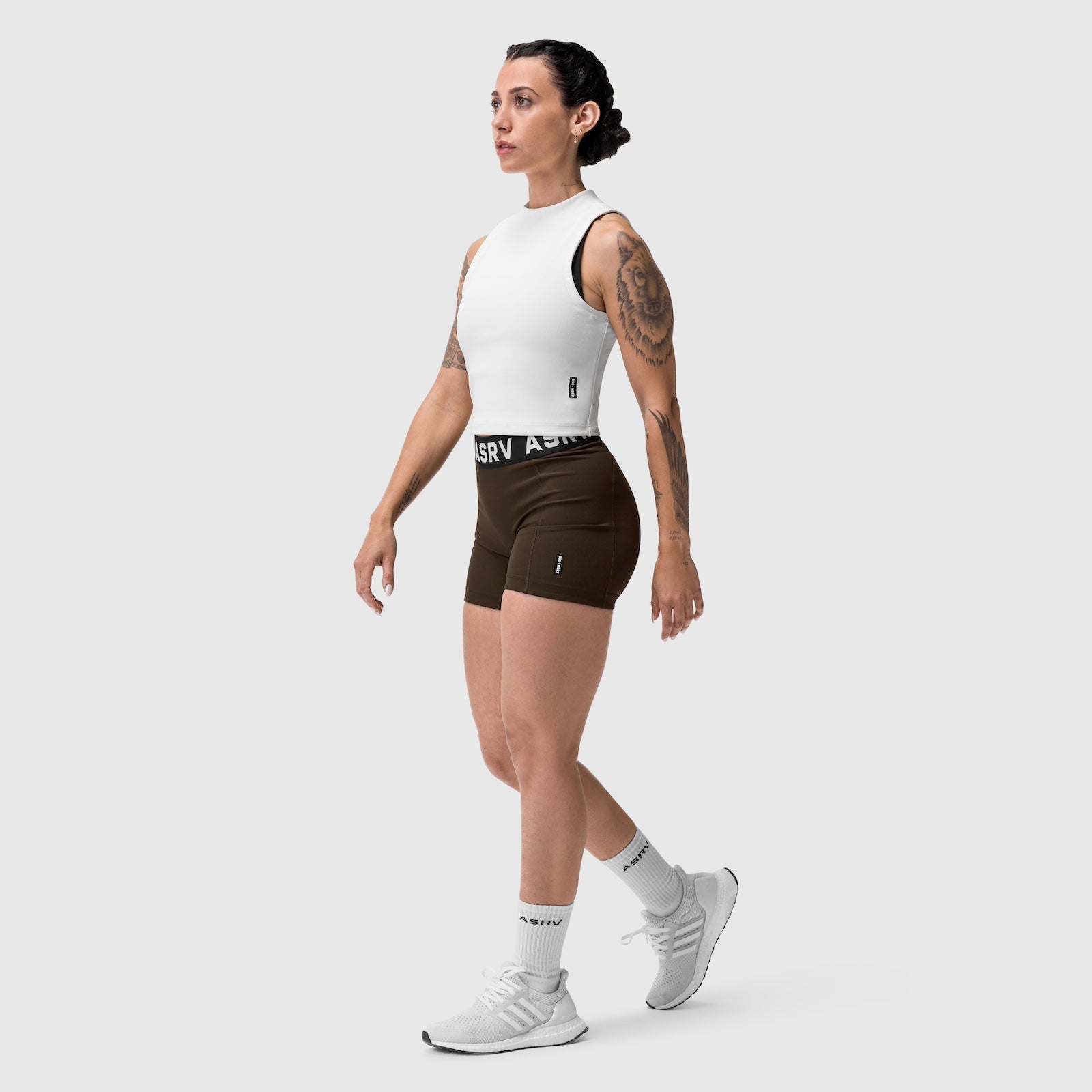 W027 Lycra Ribbed Short in Dark Earth, worn with white tank top and sneakers, side view