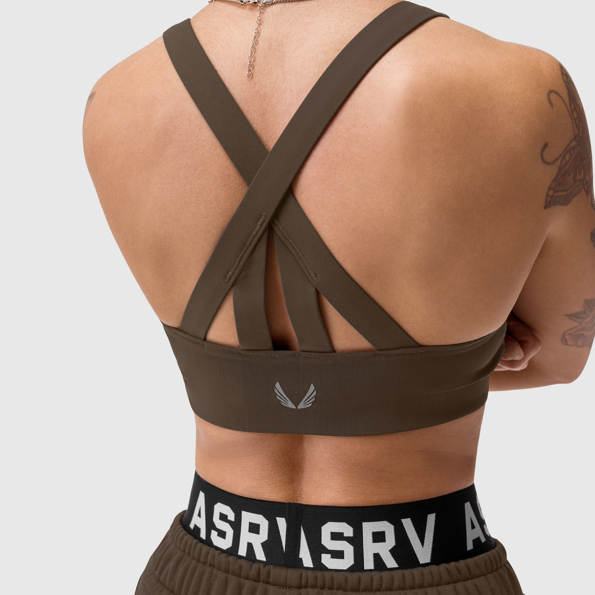 W039 Lycra Hybrid Sports Bra in dark earth, back view on model with cross-strap design