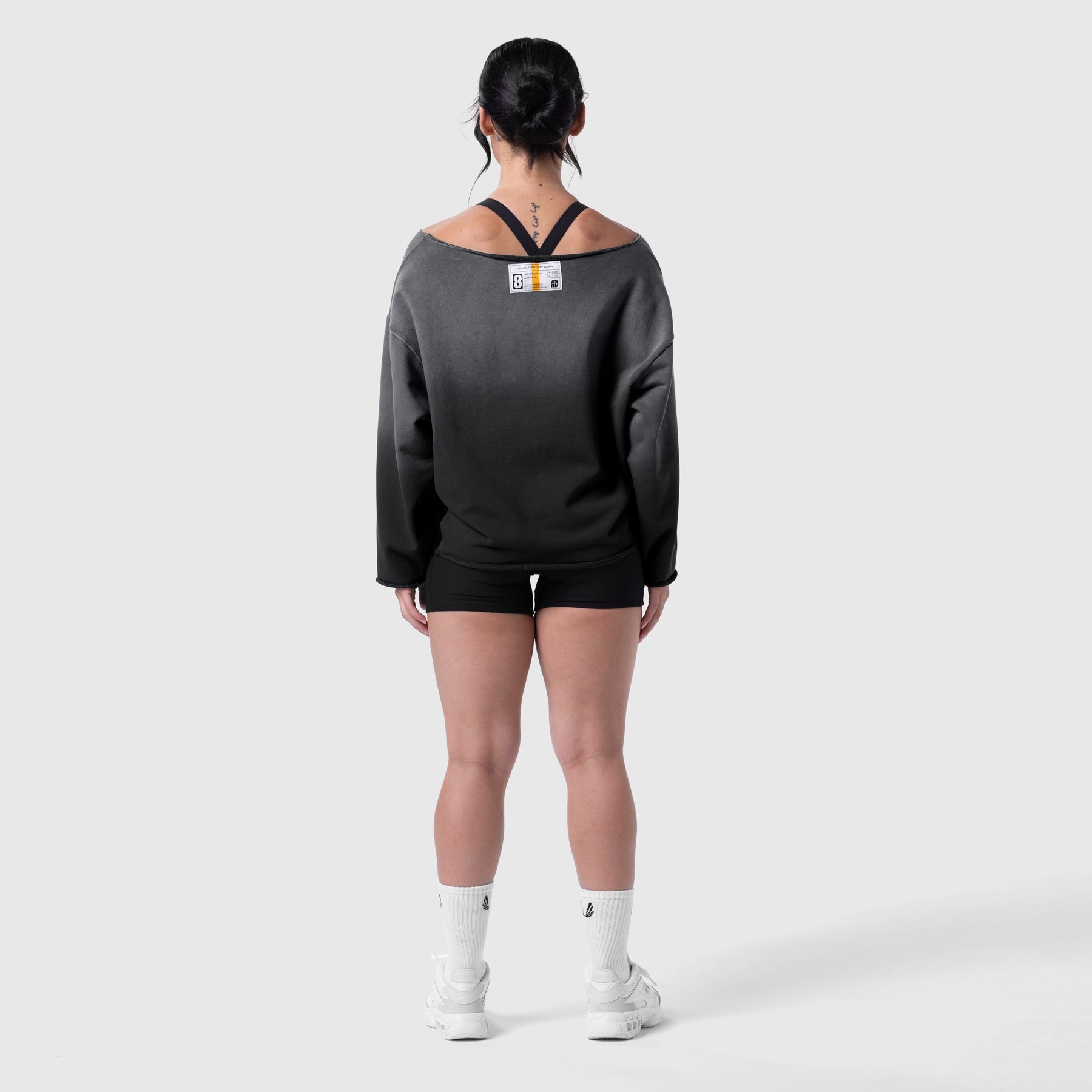Black sun fade oversized crewneck worn by model, back view, paired with black shorts and white socks
