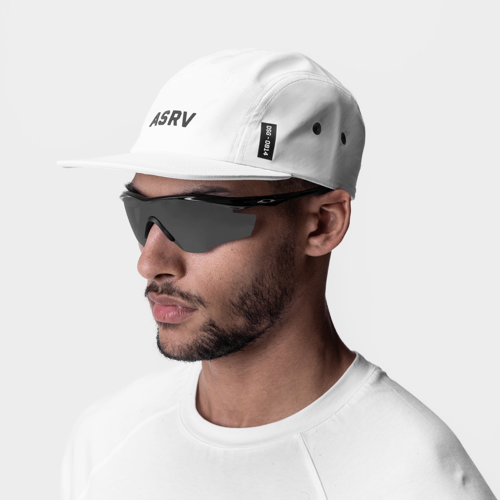 White 5-panel run cap with 'ASRV' branding, worn by model with sunglasses, side profile view