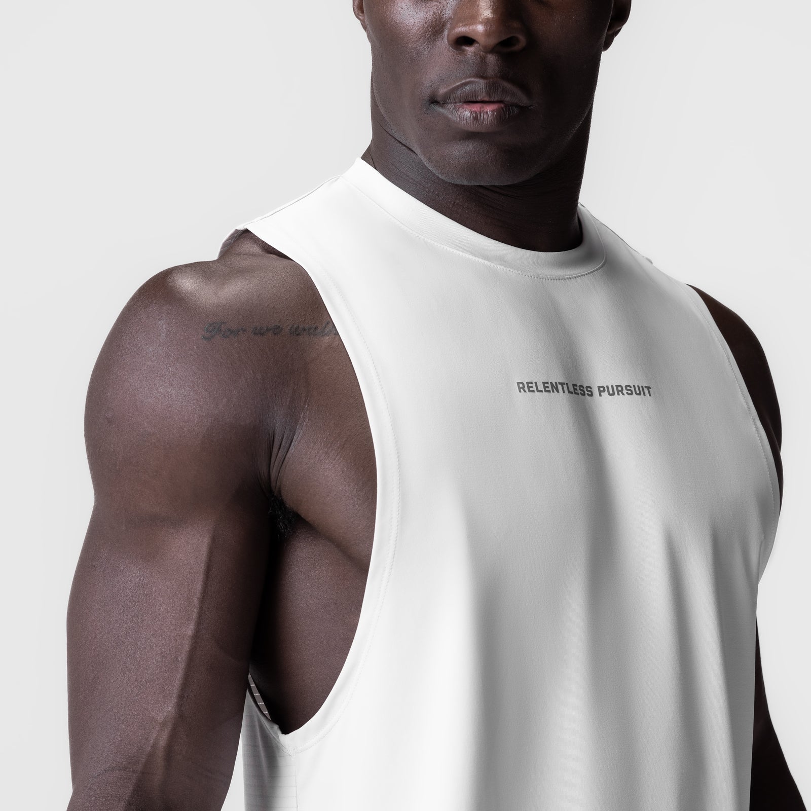 White 3D-Lite® 2.0 Lycra® muscle tank with 'RELENTLESS PURSUIT' text, worn by model, front-angled view
