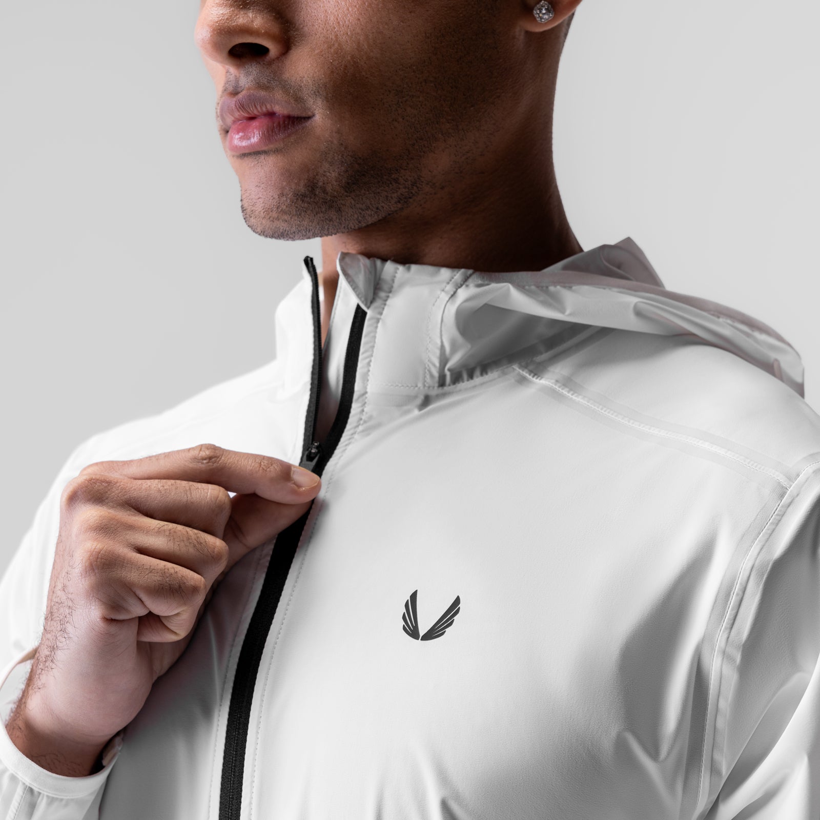White Aerotex Lightweight Windbreaker worn by model, shown from side angle holding zipper