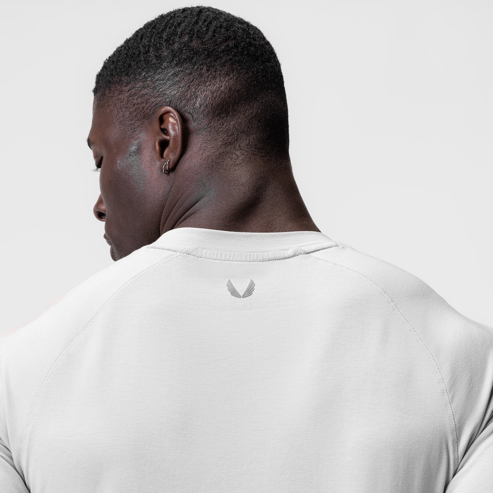 White Supima® Fitted Tee worn by model, back view showing logo