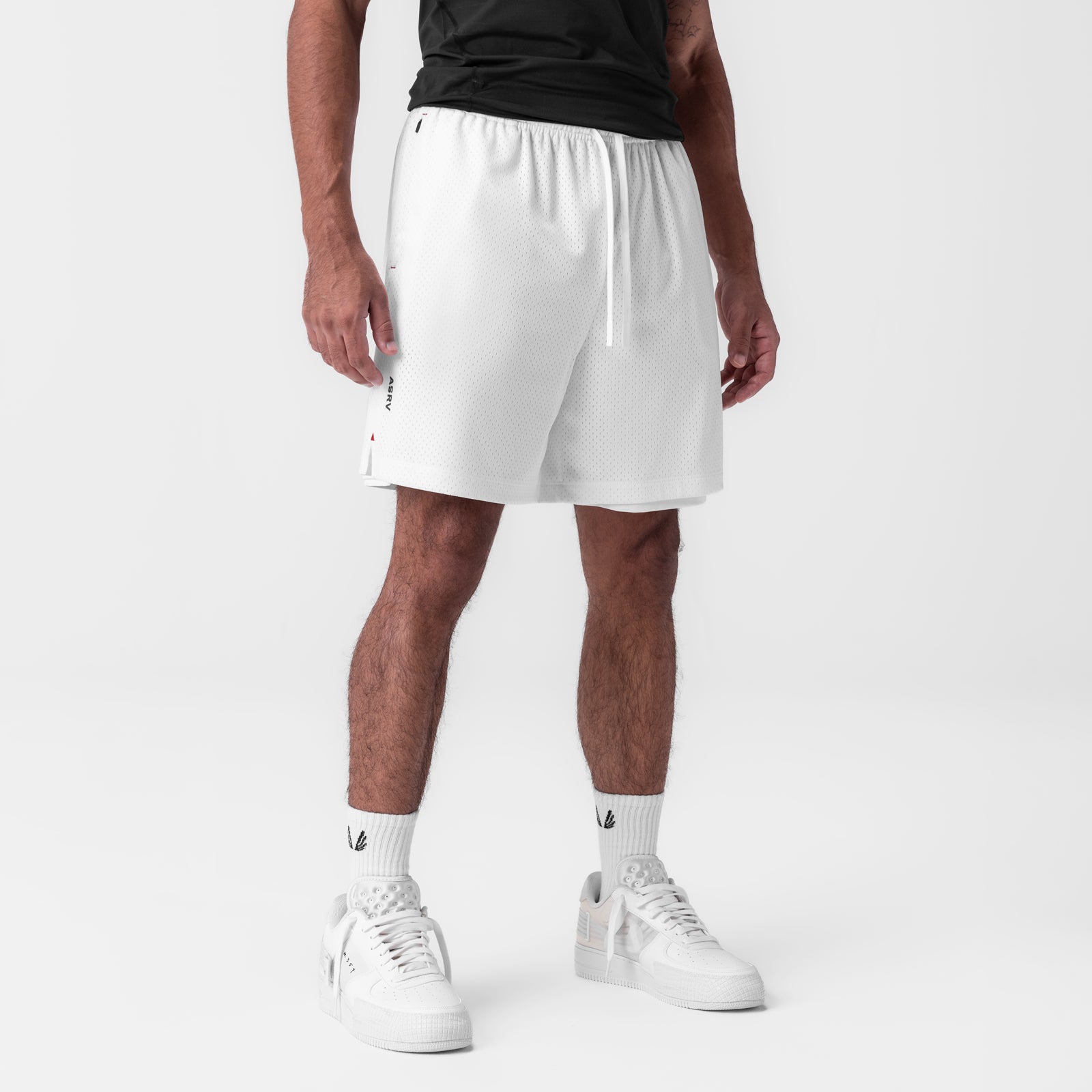 Reversible 2-in-1 shorts in white worn by model with white sneakers and socks