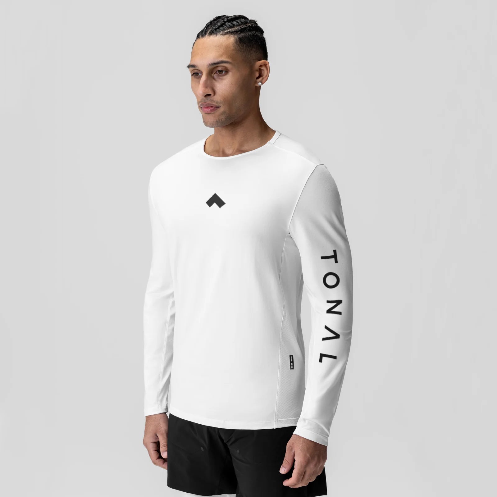 White long sleeve shirt with tonal branding, worn by model in profile pose