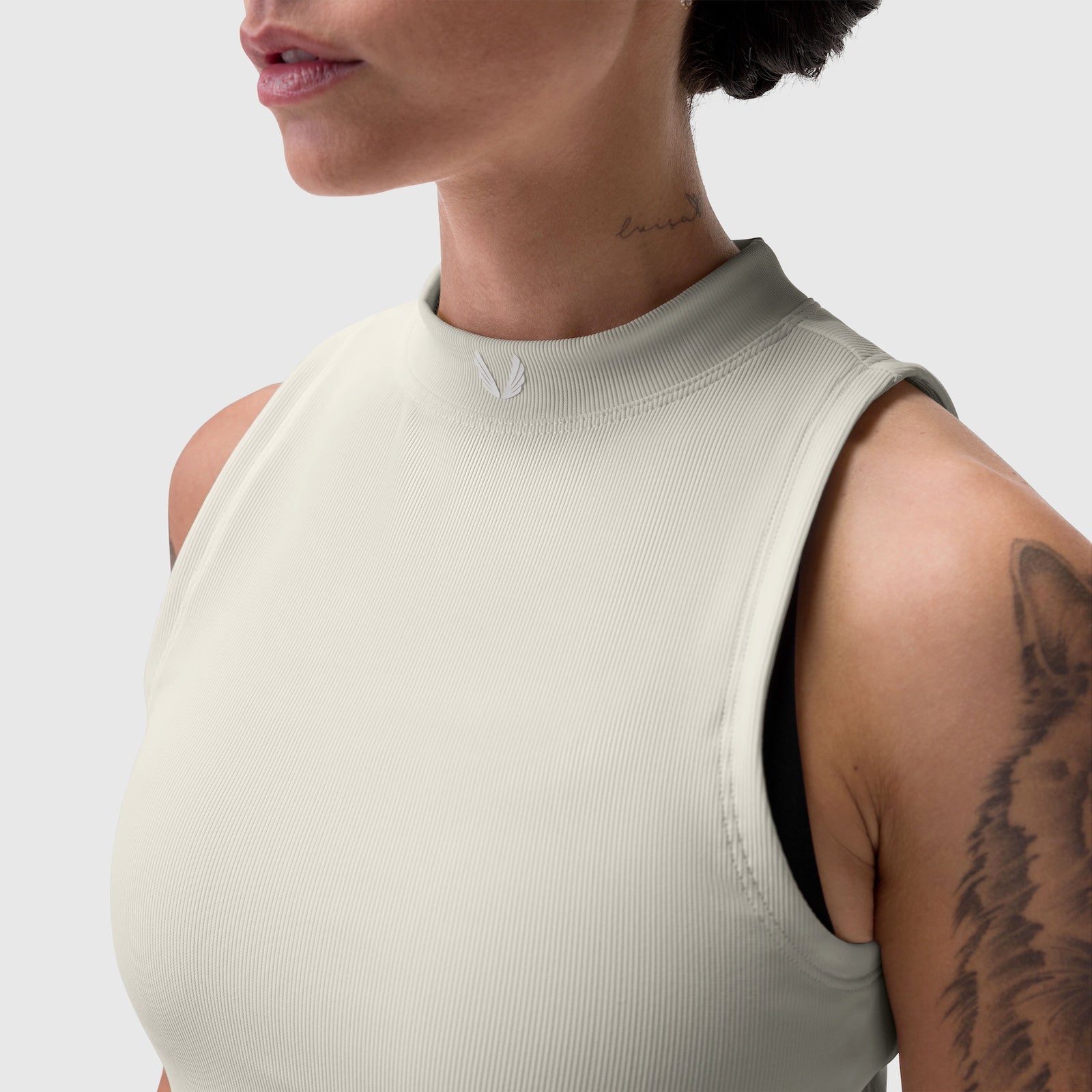 Lycra ribbed mockneck tank in ivory cream worn by model, side view