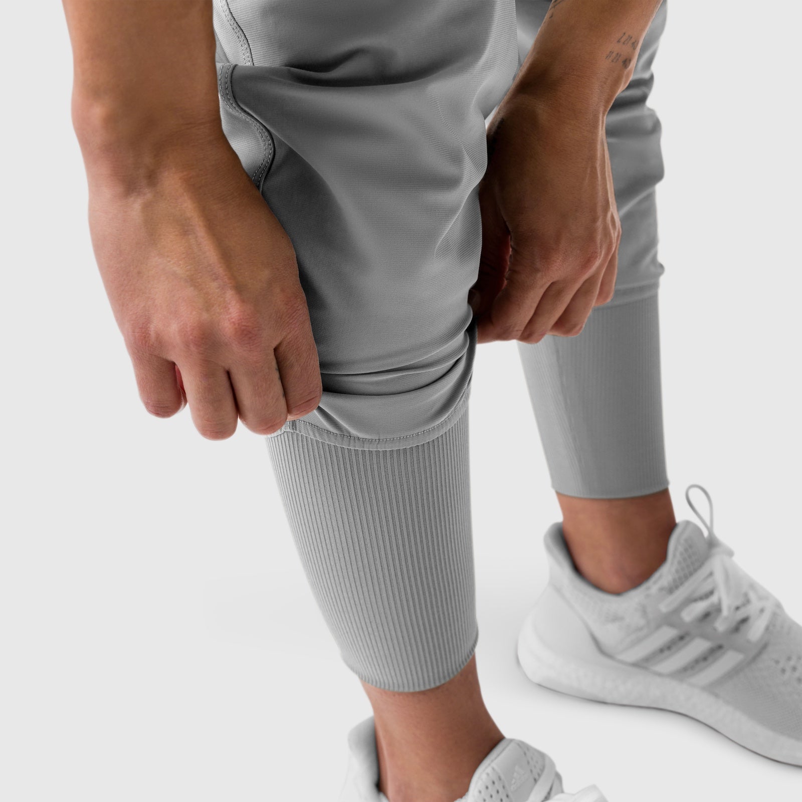 Tetra-Lite Cargo High Rib Jogger in Slate Grey, model wearing jogger with hands adjusting leg cuff
