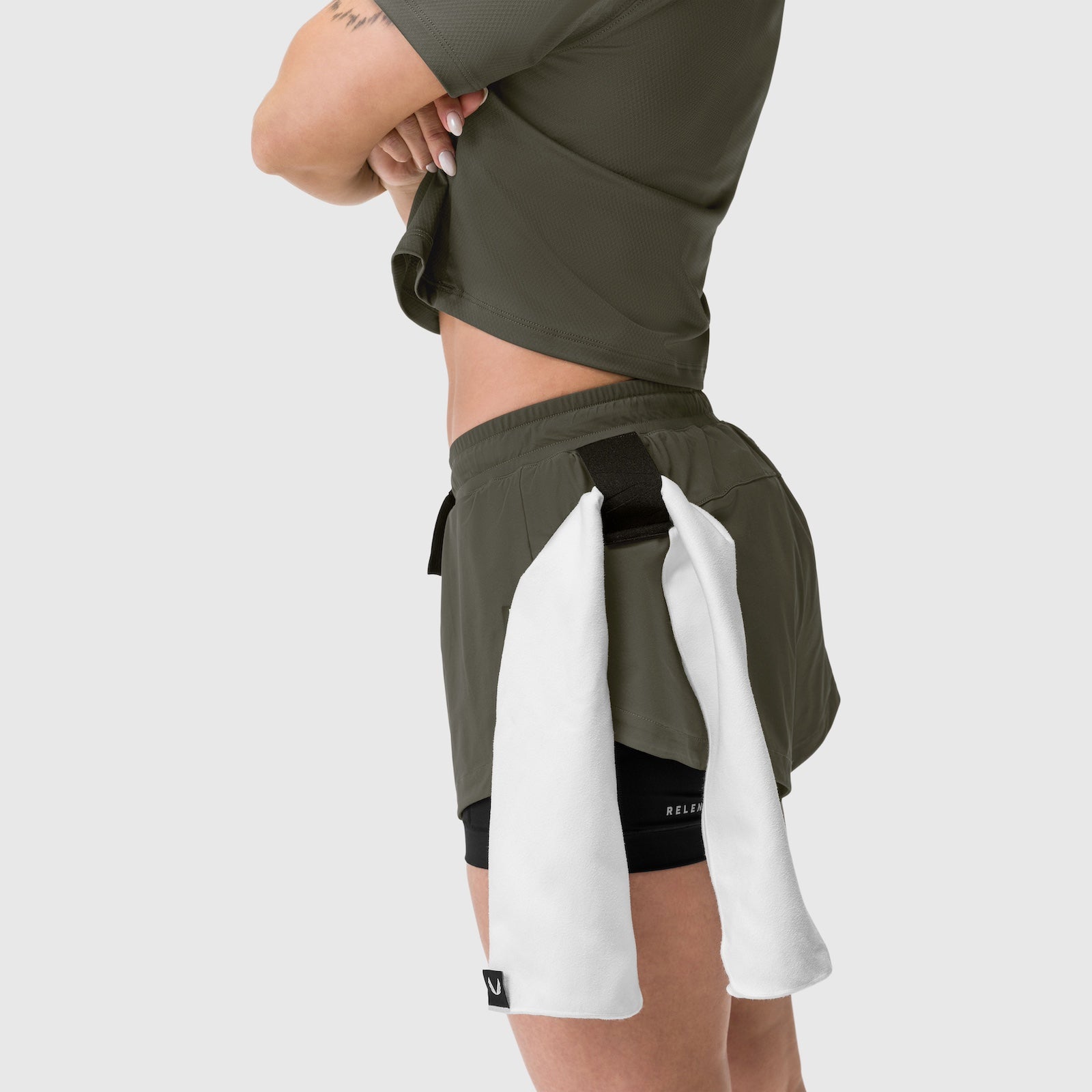 Tetra-Lite Liner Short in olive worn by model with white towel draped over shoulder, side view