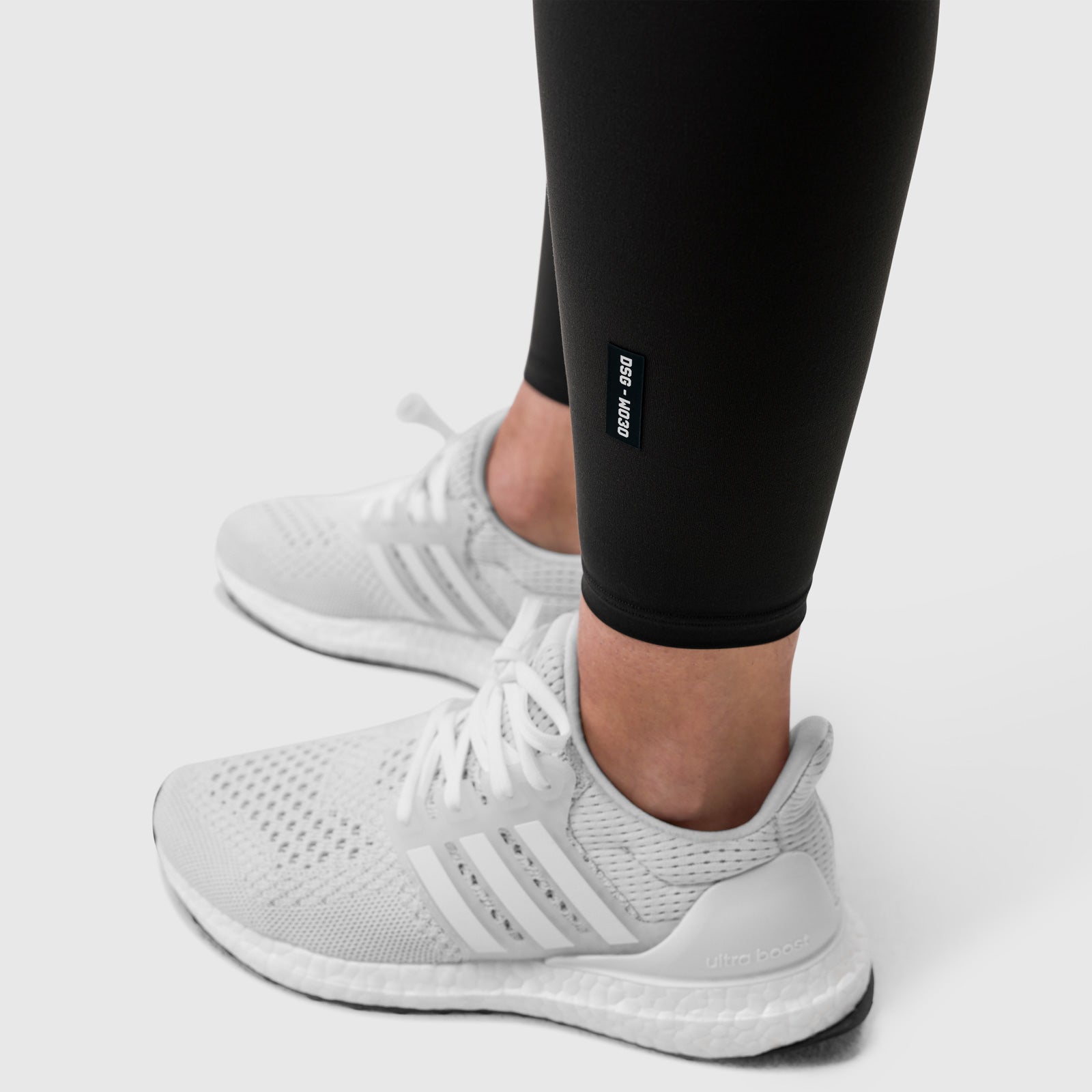 Black LYCRA® 3-in-1 Legging worn with white sneakers, side view